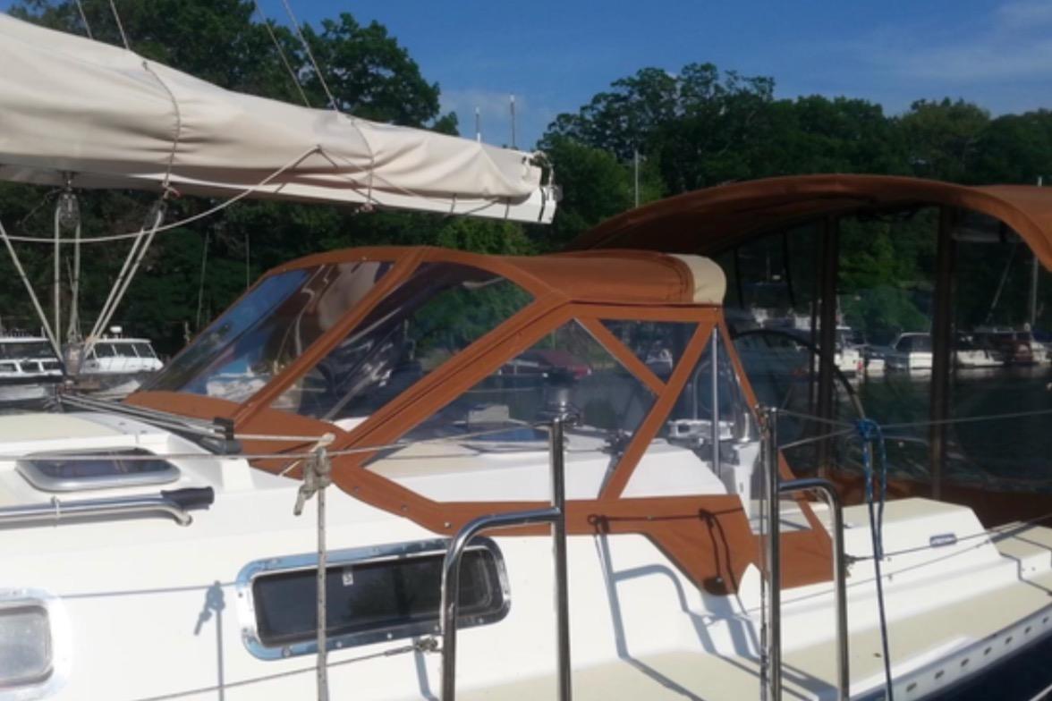 Sailboat Freedom 35, 1995 model, docked with brown canopy and clear windows.