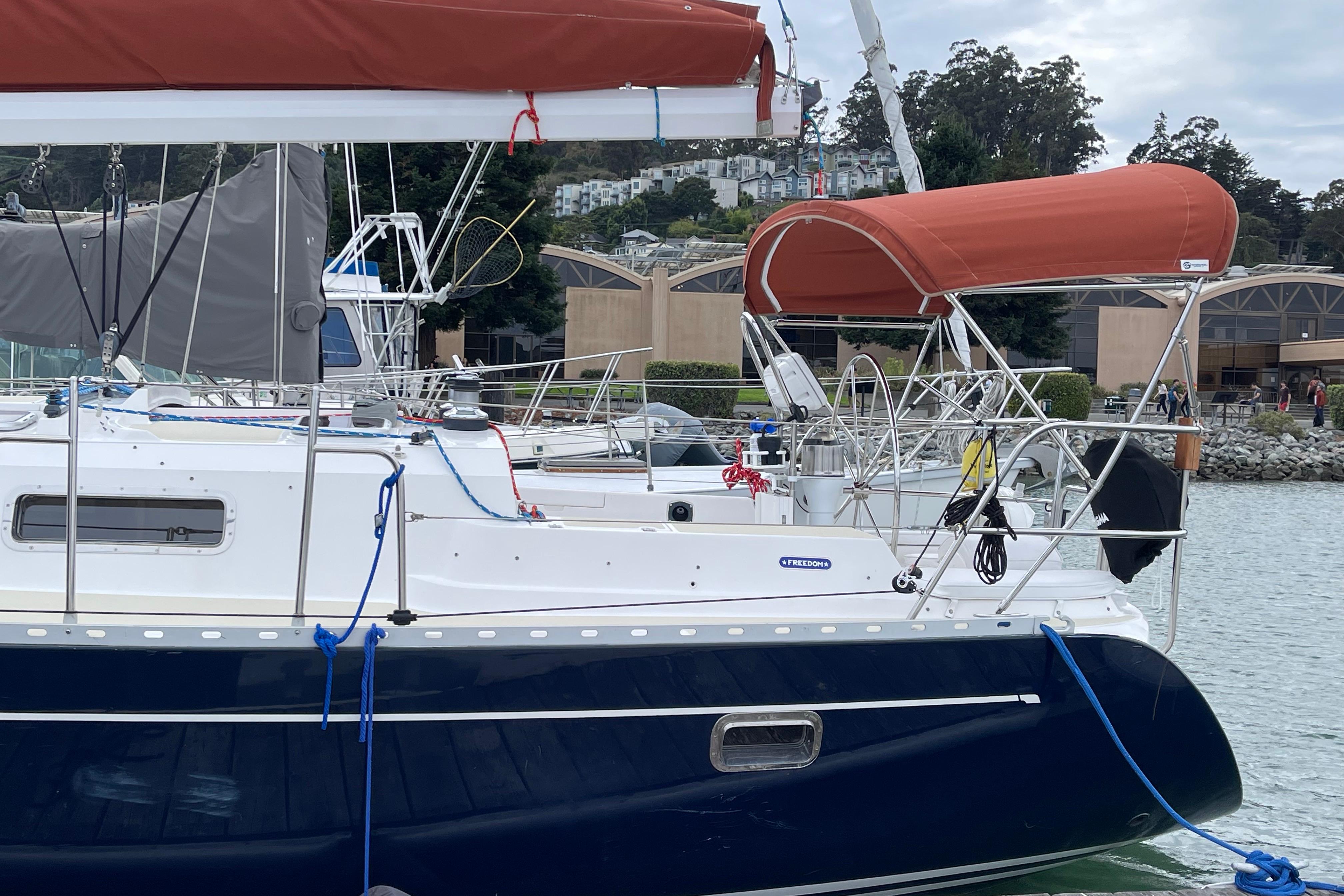 Sailboat Freedom 35, 1995 model, docked with red canopy and blue hull.