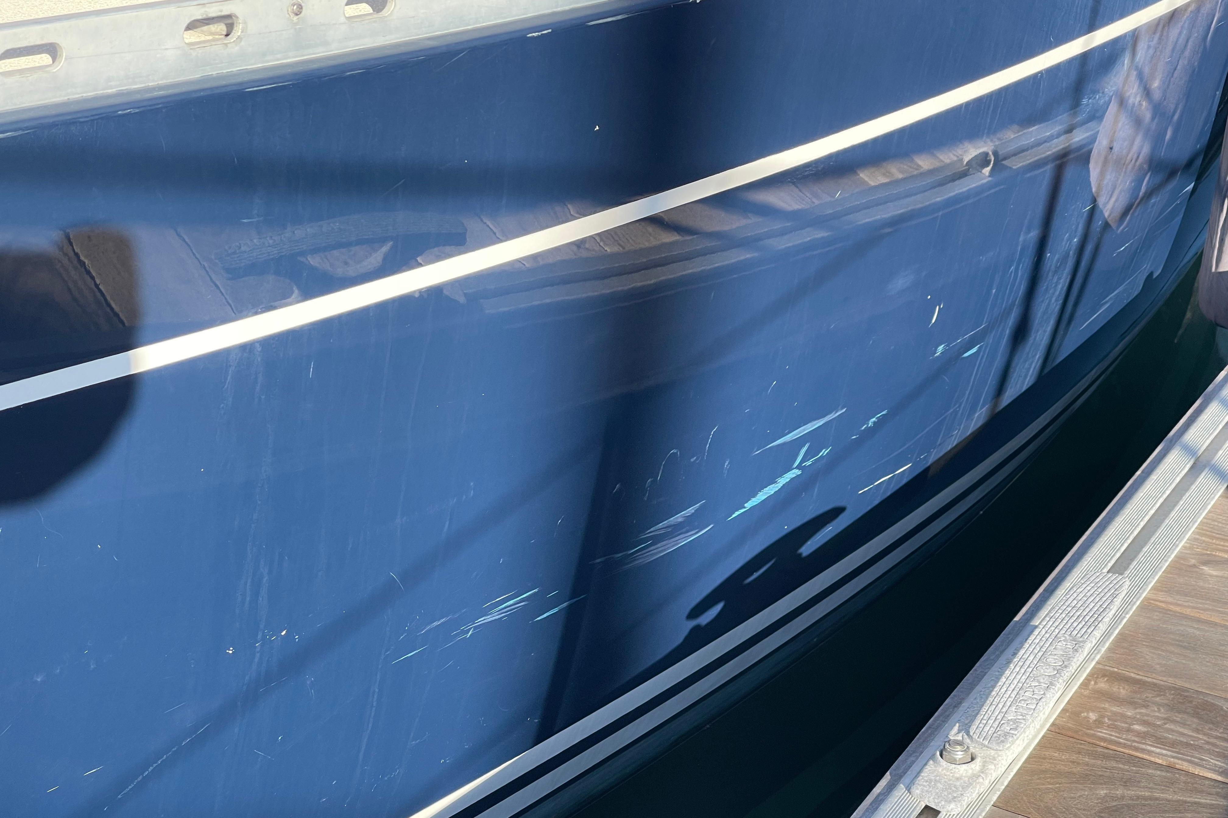 Blue Freedom 35 boat from 1995 with visible scratches on the hull.