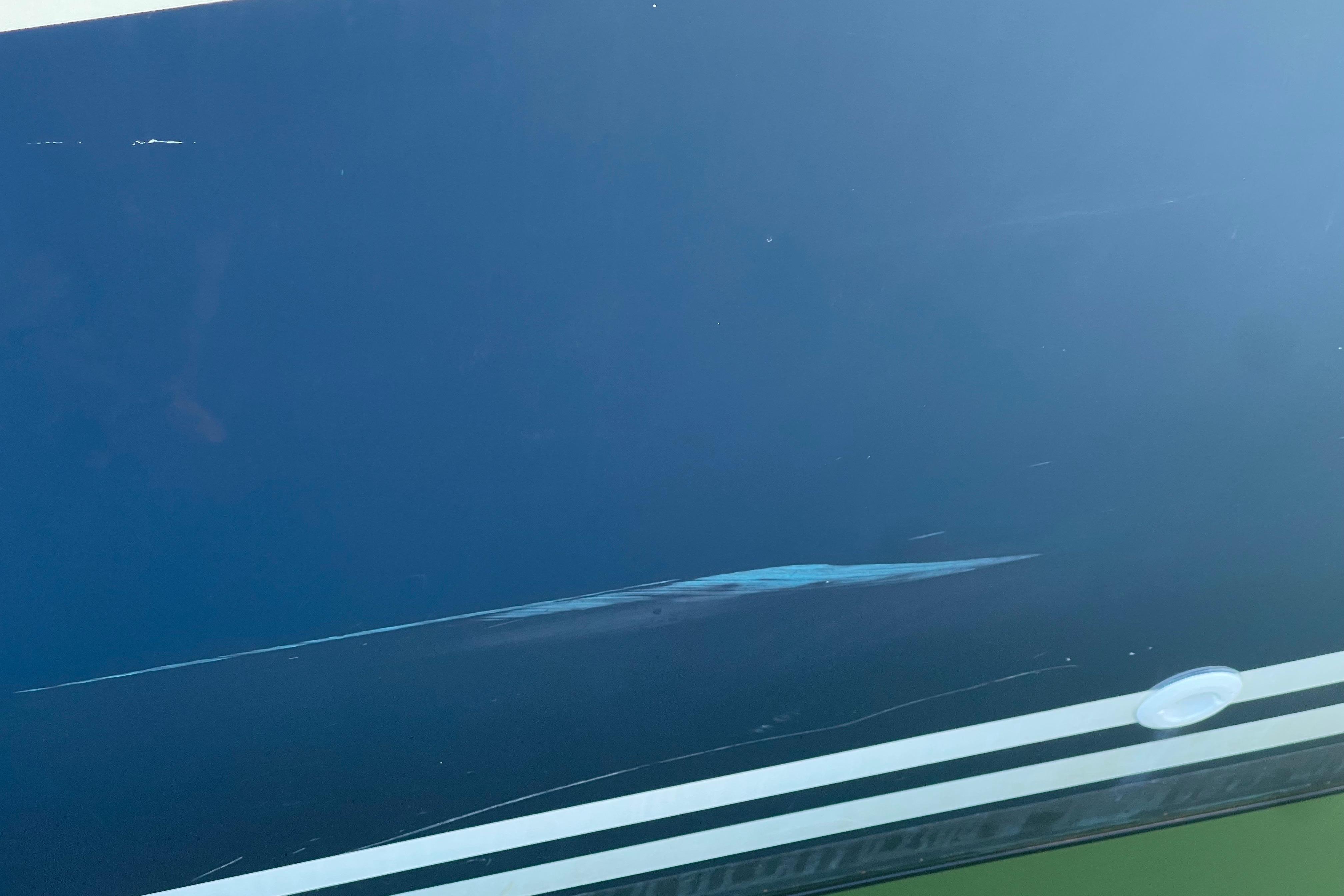 Close-up of a 1995 Freedom 35 boat hull with visible scratches.