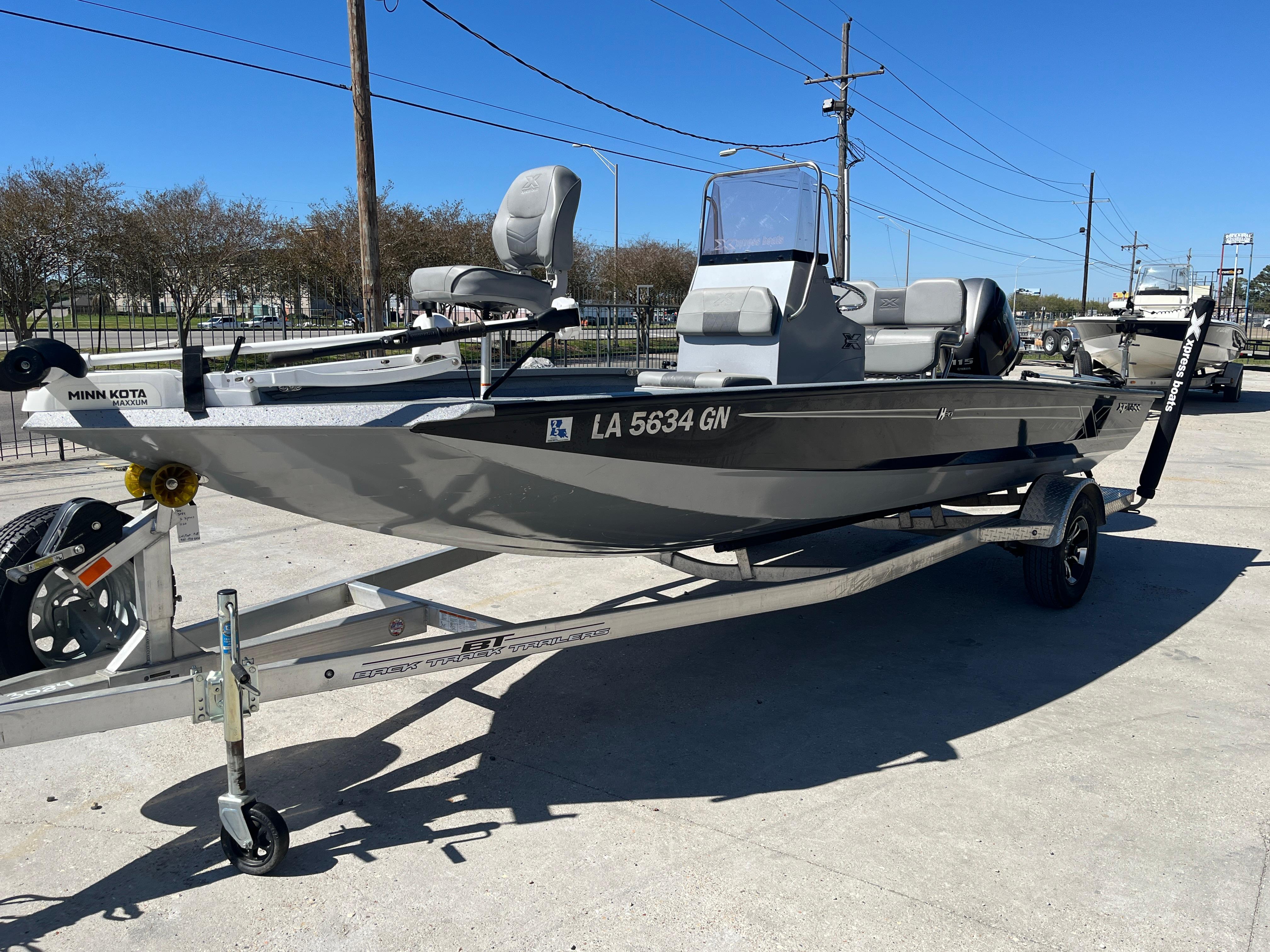 2022 Xpress H20B Bay Boat on trailer, parked outdoors under clear blue sky.