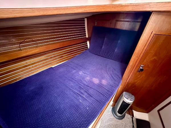 1986 Nonsuch Ultra cabin with blue bedding and wooden interior.