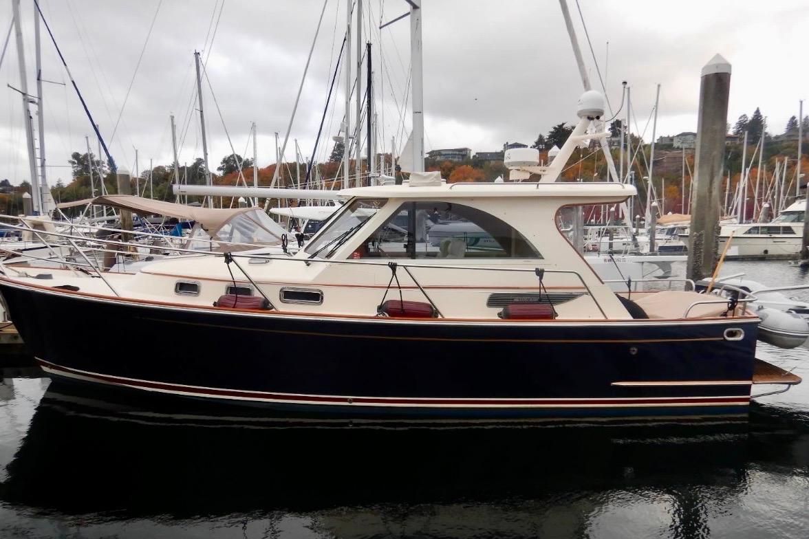 2007 Legacy Yachts 32 docked in a marina, surrounded by sailboats.