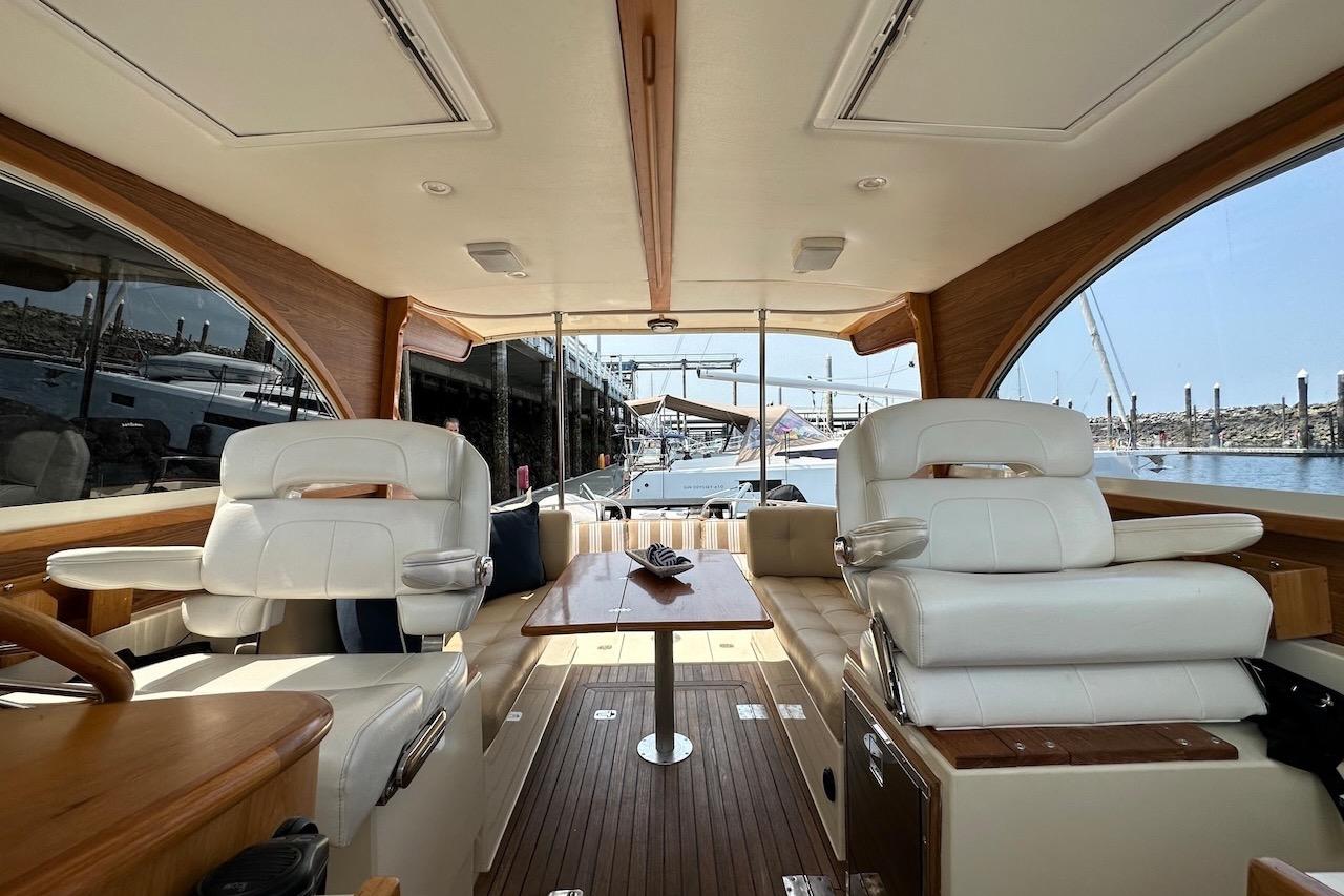 Interior of 2007 Legacy Yachts 32, featuring elegant seating and wooden accents.