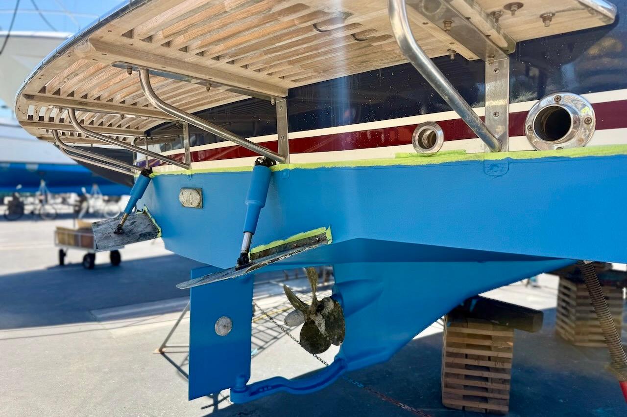 2007 Legacy Yachts 32, blue hull, dry docked for maintenance, stern view.