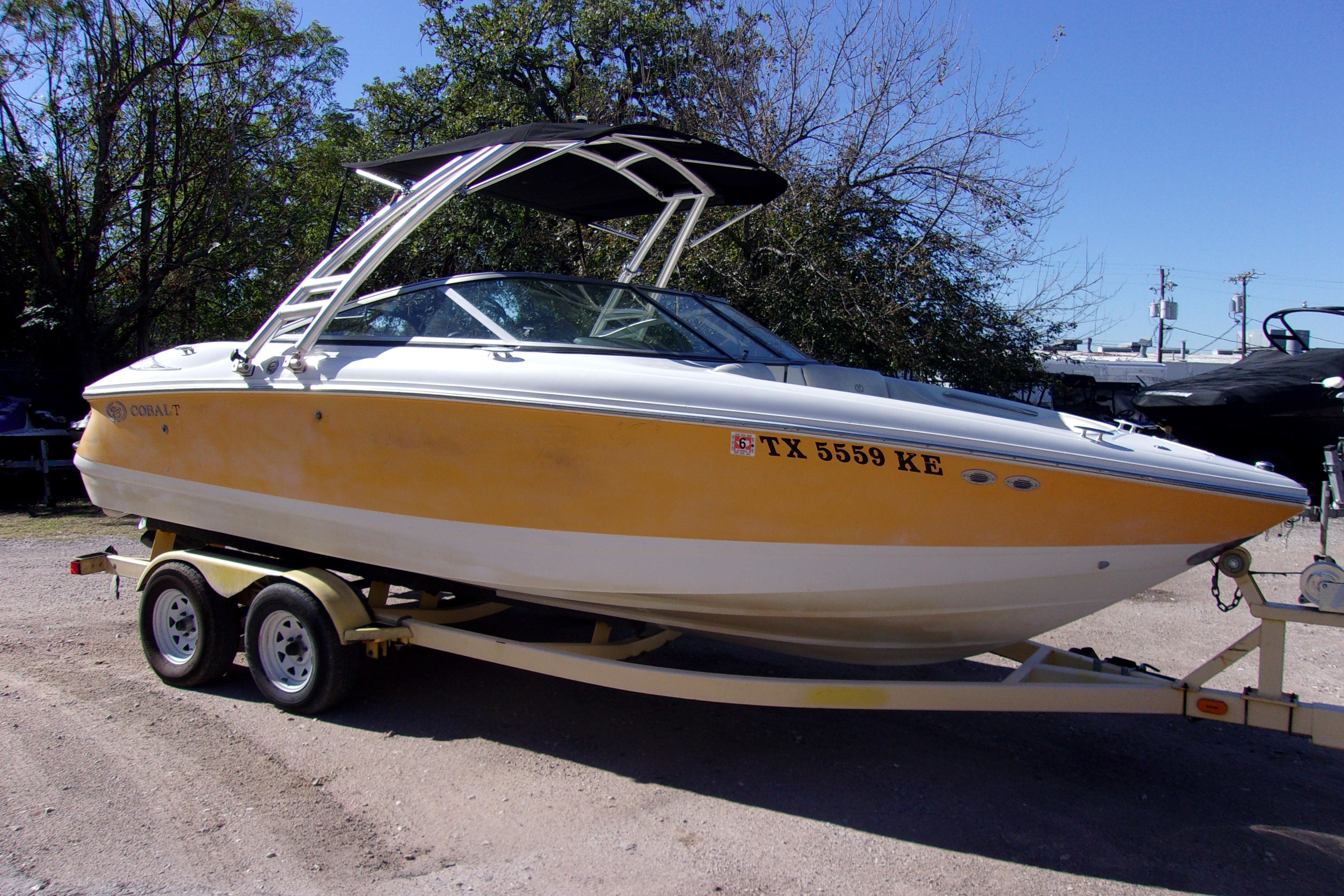 2005 Cobalt 200 boat on trailer, yellow and white, parked outdoors.