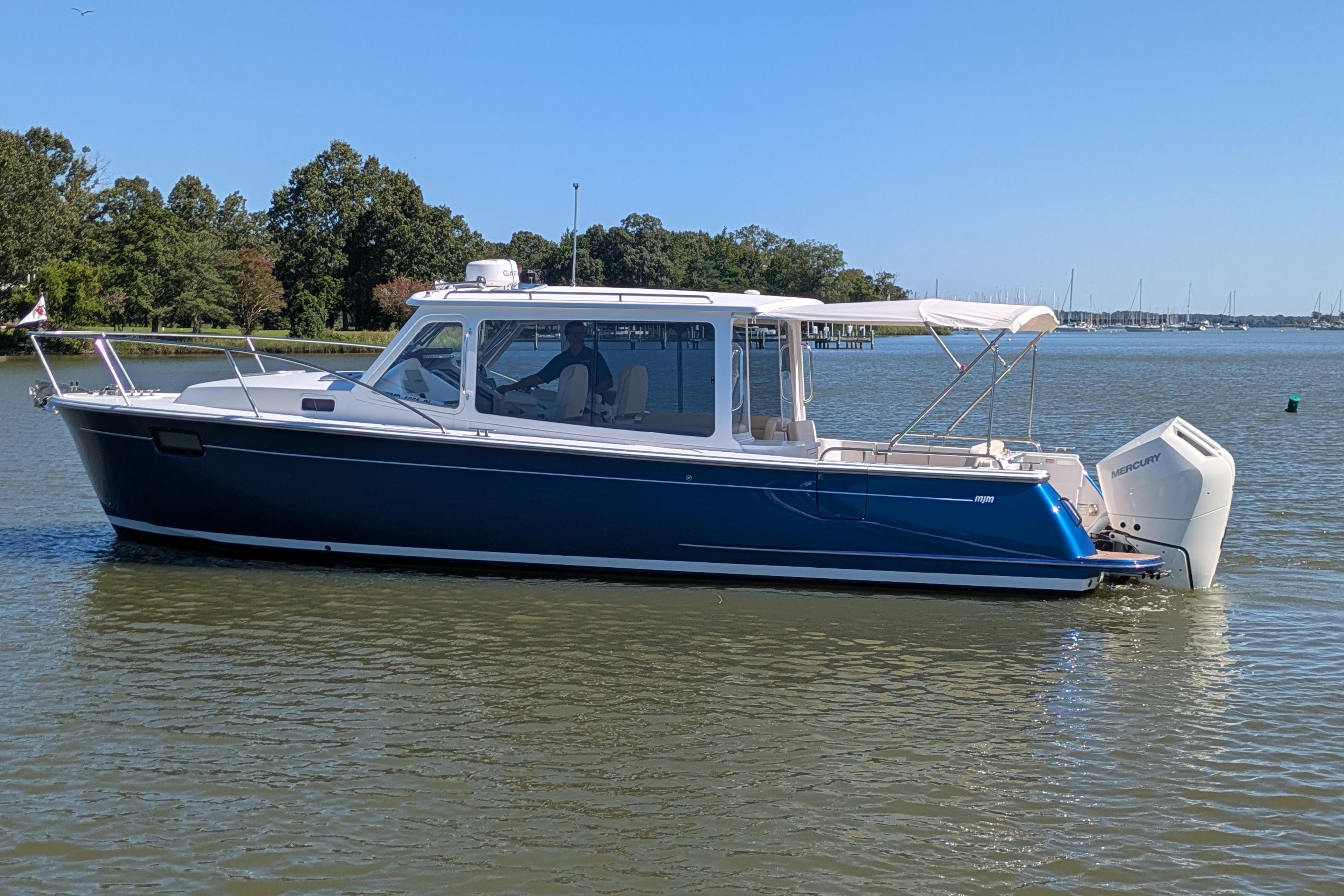 2024 MJM 35 boat on calm water with trees in the background.