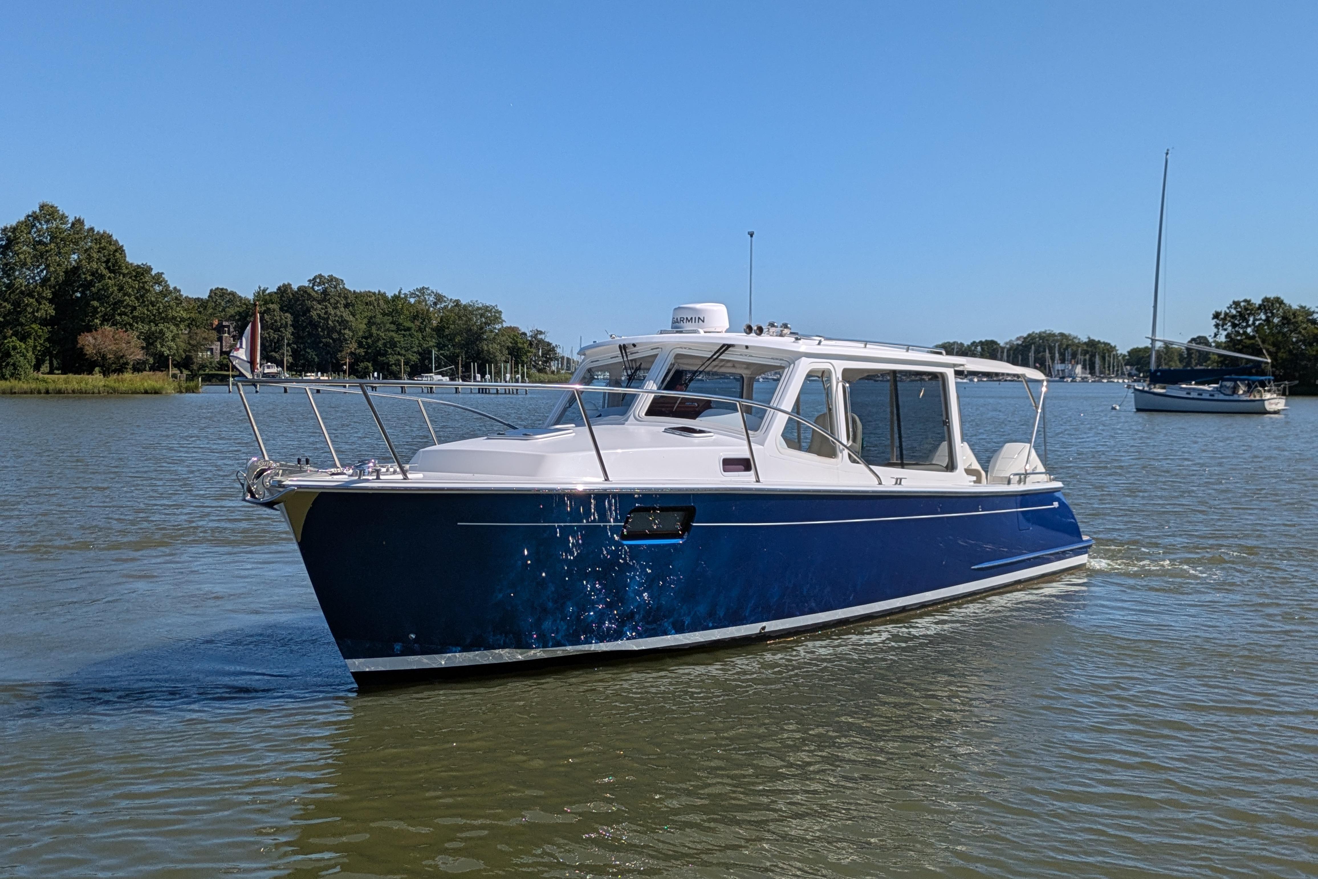 2024 MJM 35 boat cruising on a calm lake under a clear blue sky.