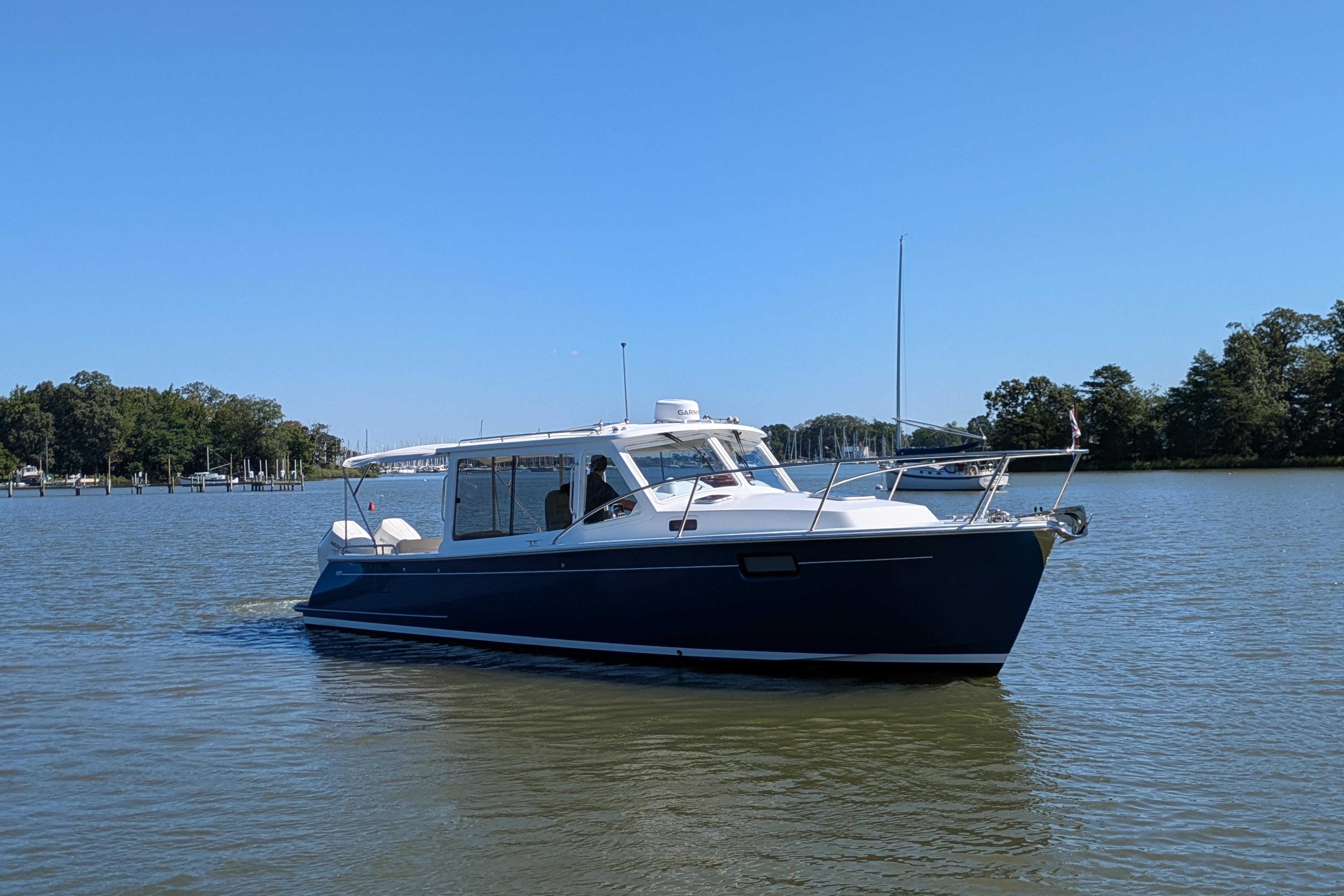 2024 MJM 35 boat cruising on a calm lake under a clear blue sky.