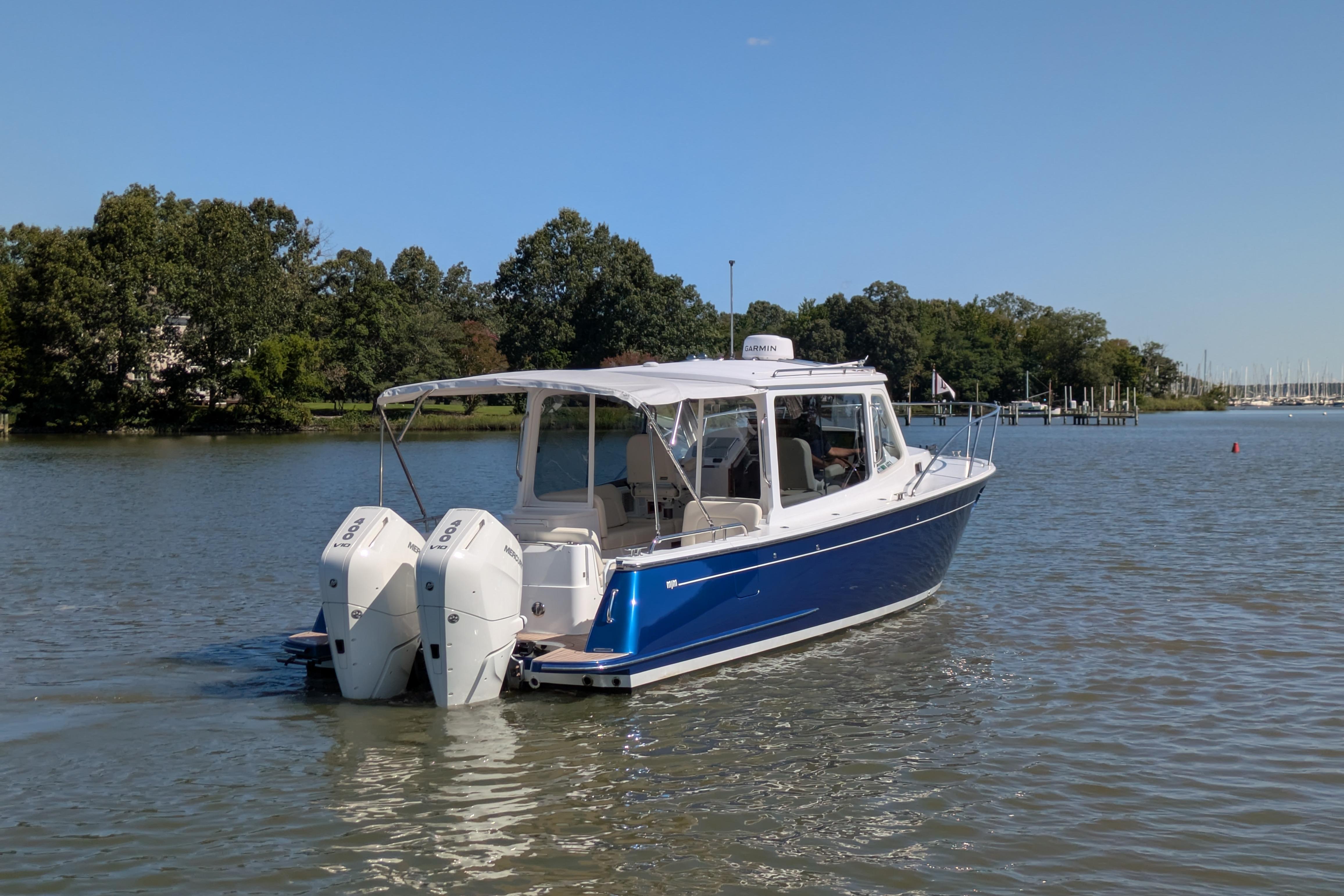 2024 MJM 35 boat with dual engines on a calm lake.