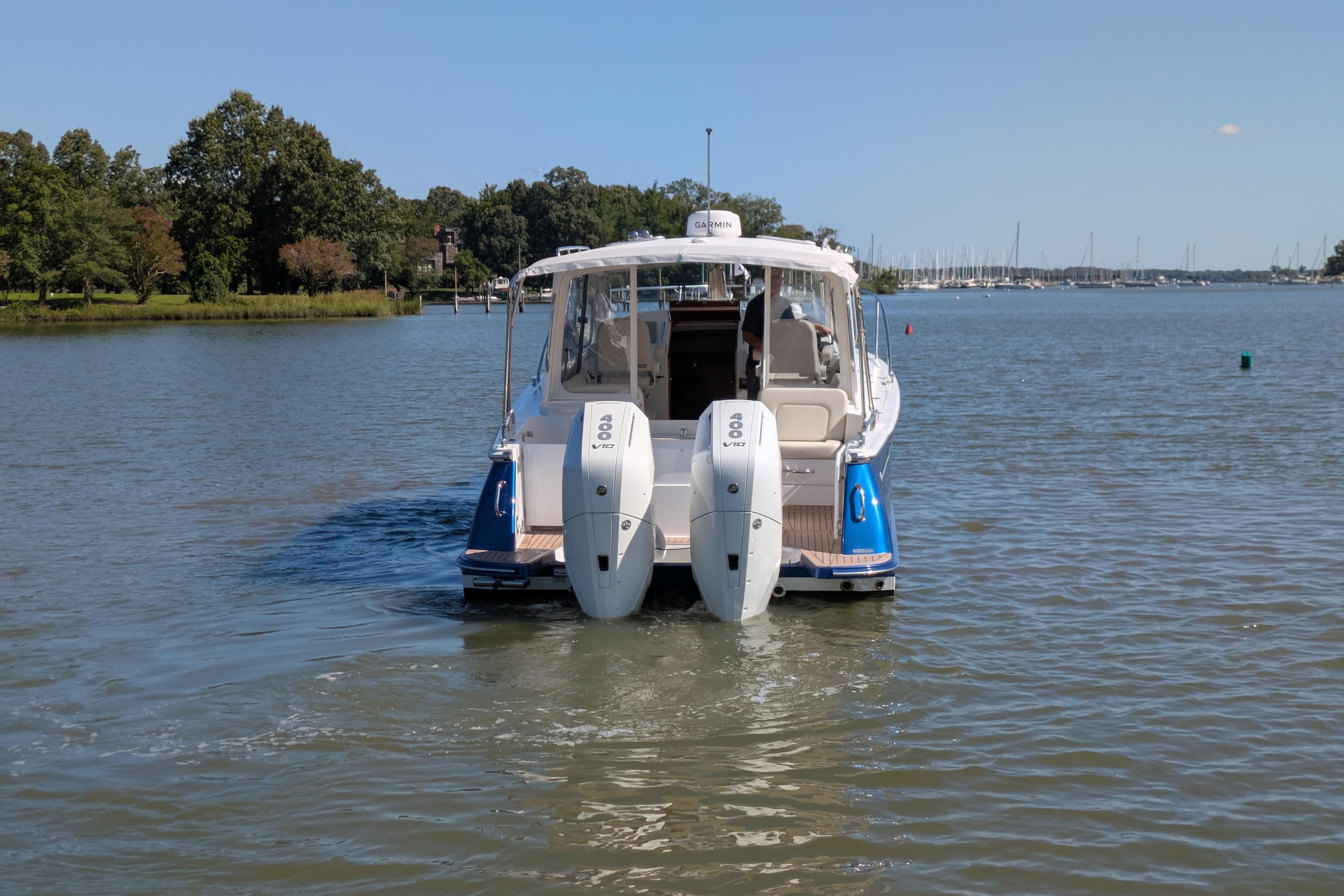 2024 MJM 35 boat with dual outboard engines cruising on a calm lake.