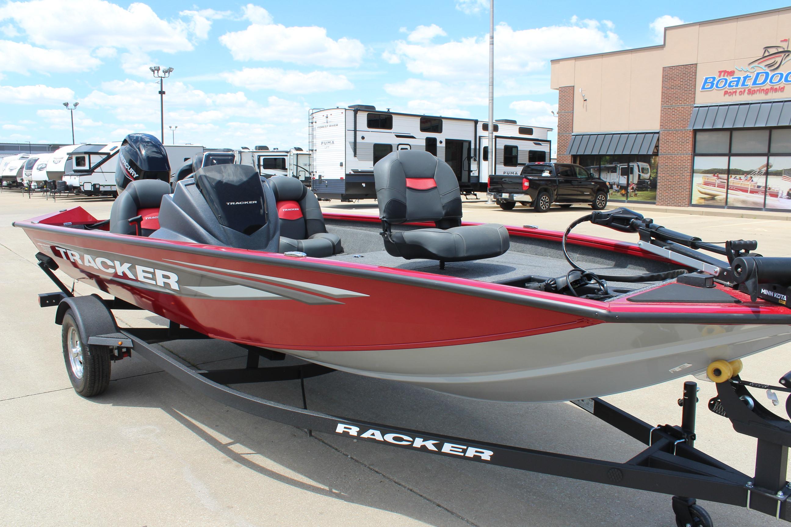 2025 Tracker Pro Team 175 boat, red and gray, parked outside dealership.