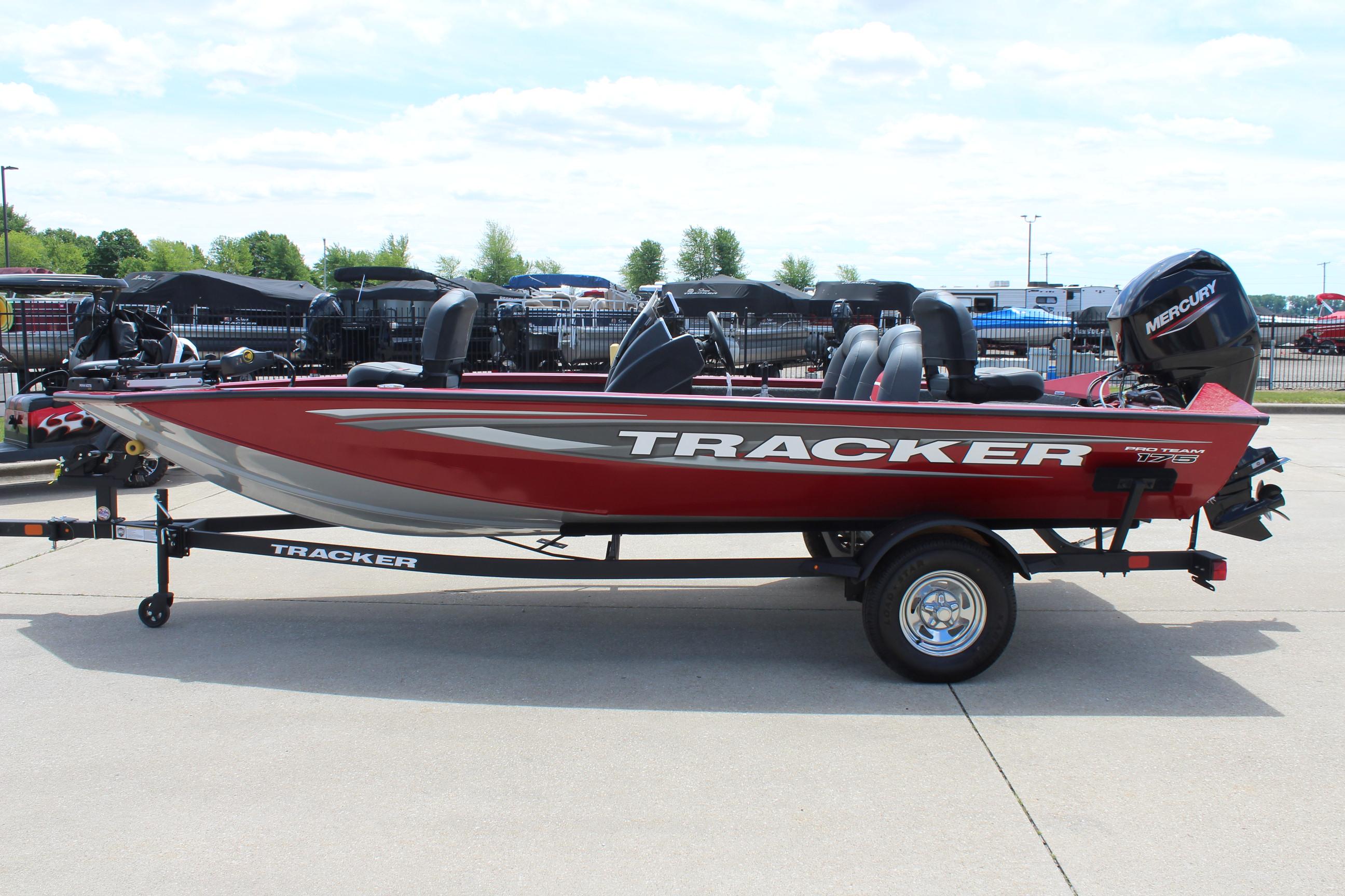 2025 Tracker Pro Team 175 boat, red with silver accents, on a trailer in a parking lot.