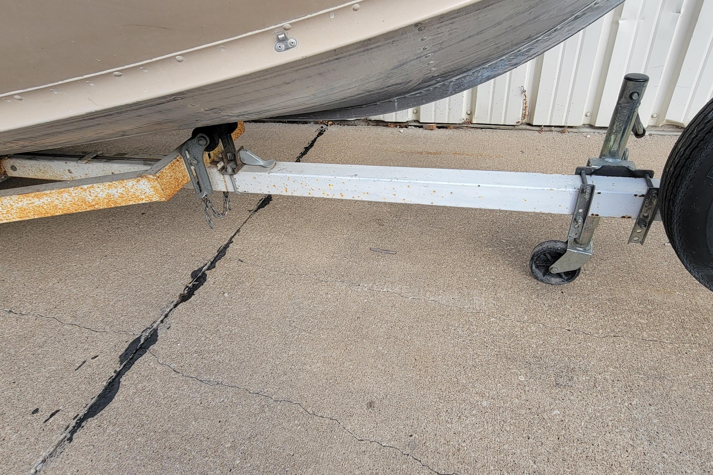 1987 Alumacraft Classic 165 CS boat trailer with visible rust on concrete surface.