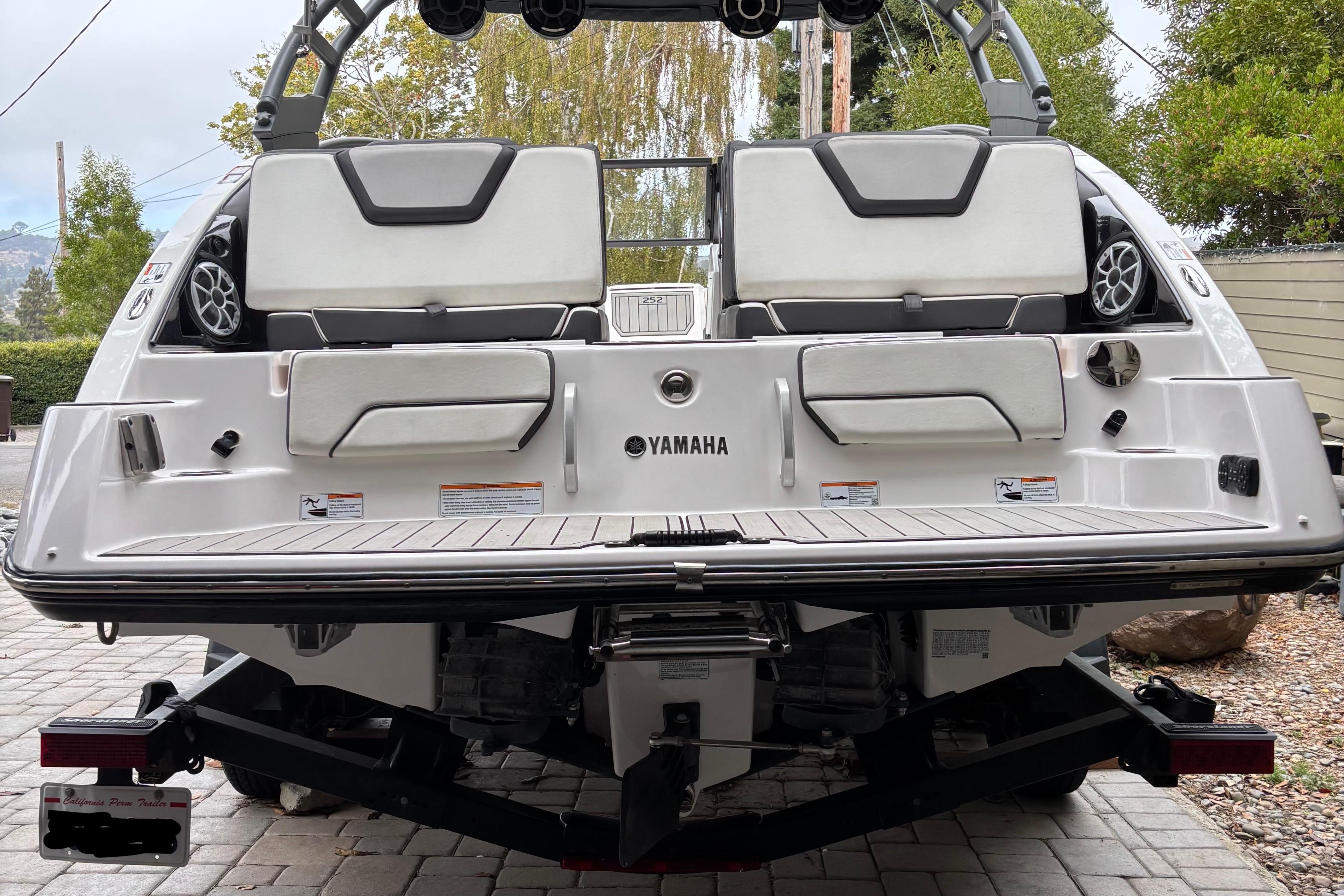 2022 Yamaha Boats 252S rear view, showcasing seating and speakers on a trailer.