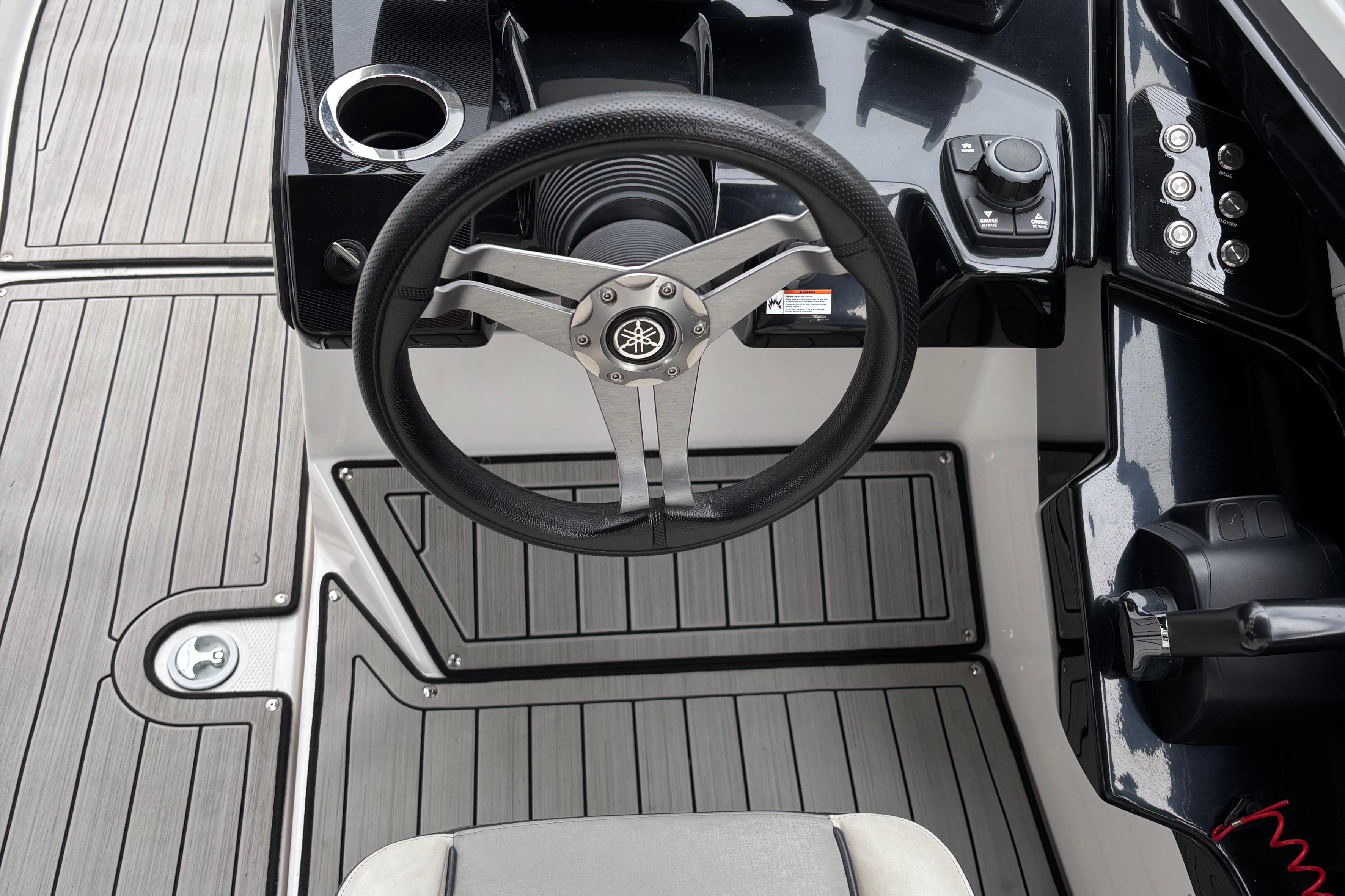 2022 Yamaha Boats 252S steering wheel and dashboard, featuring sleek design and controls.