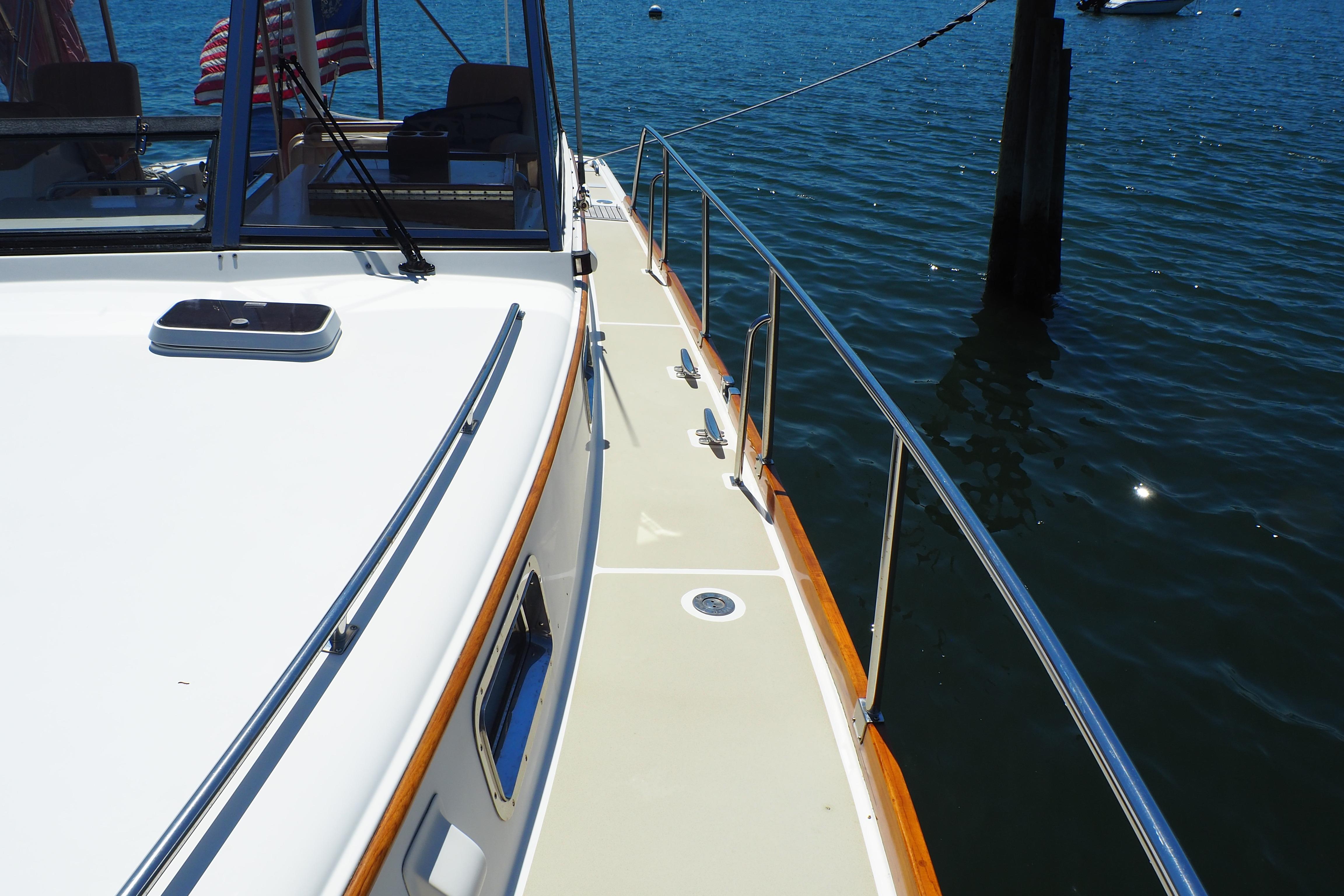1995 Grand Banks 38 Eastbay EX yacht deck with railing, docked on calm water.