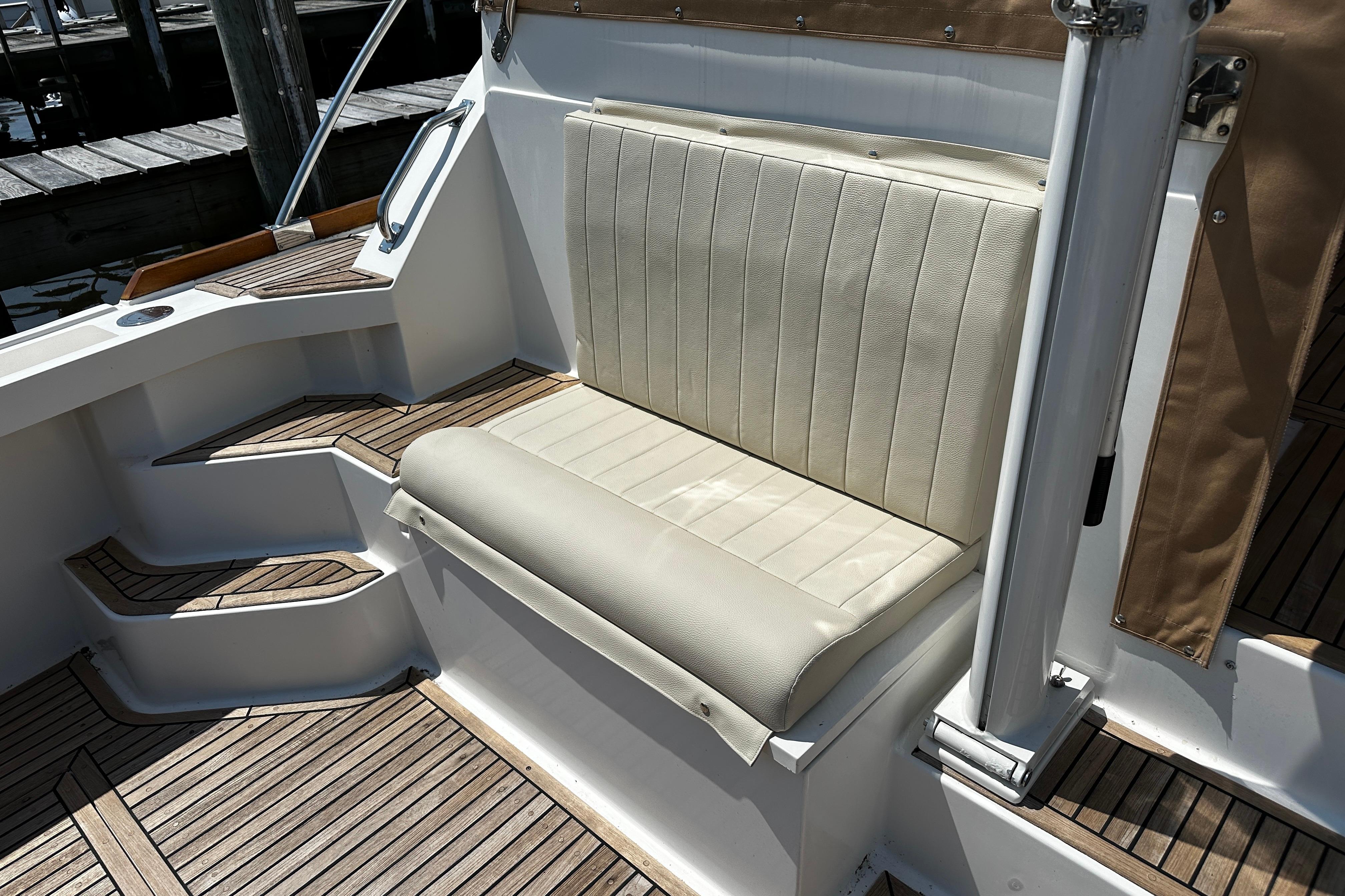 1995 Grand Banks 38 Eastbay EX boat seating with teak flooring and white upholstery.