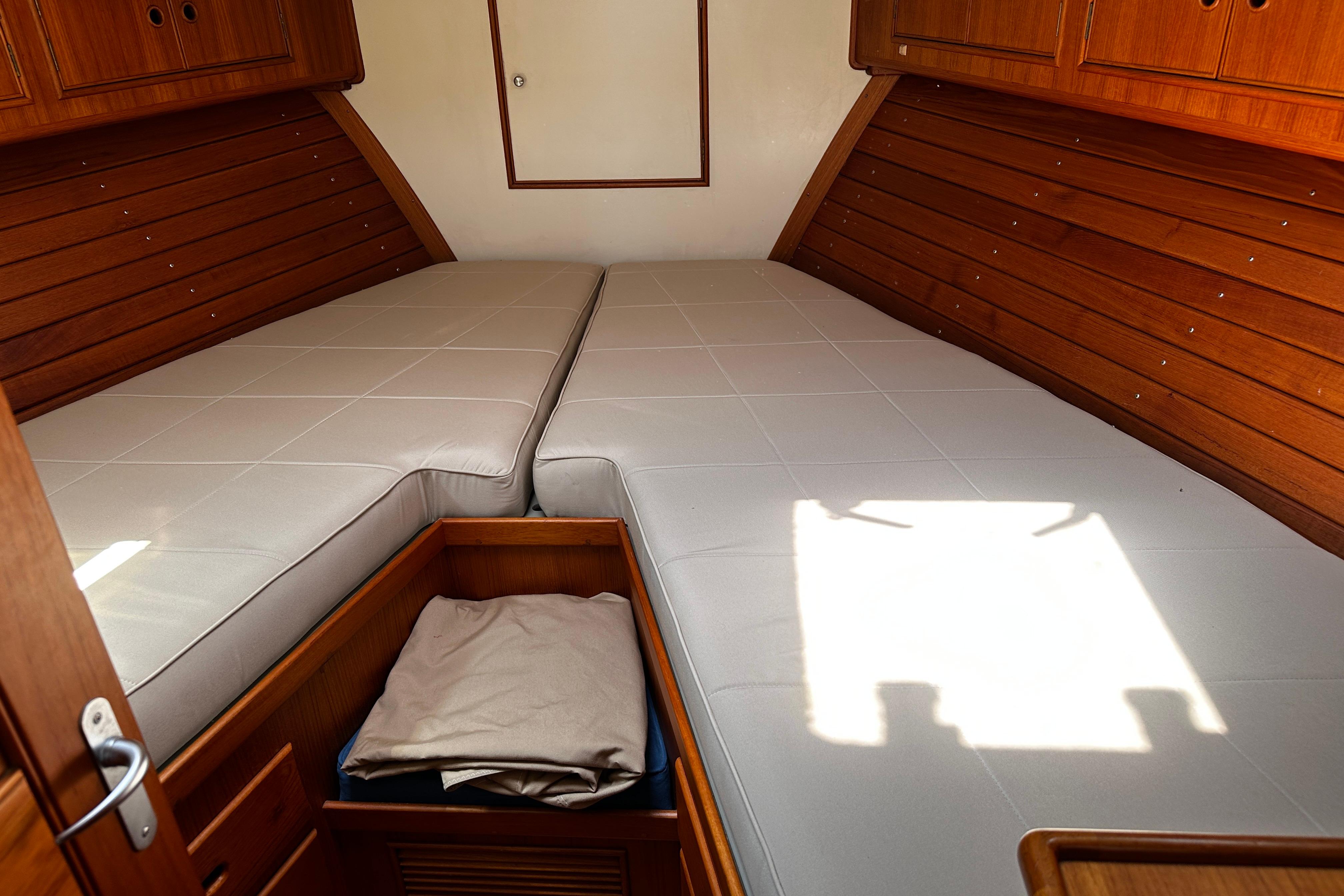 Cabin interior of 1995 Grand Banks 38 Eastbay EX with twin beds and wooden cabinetry.