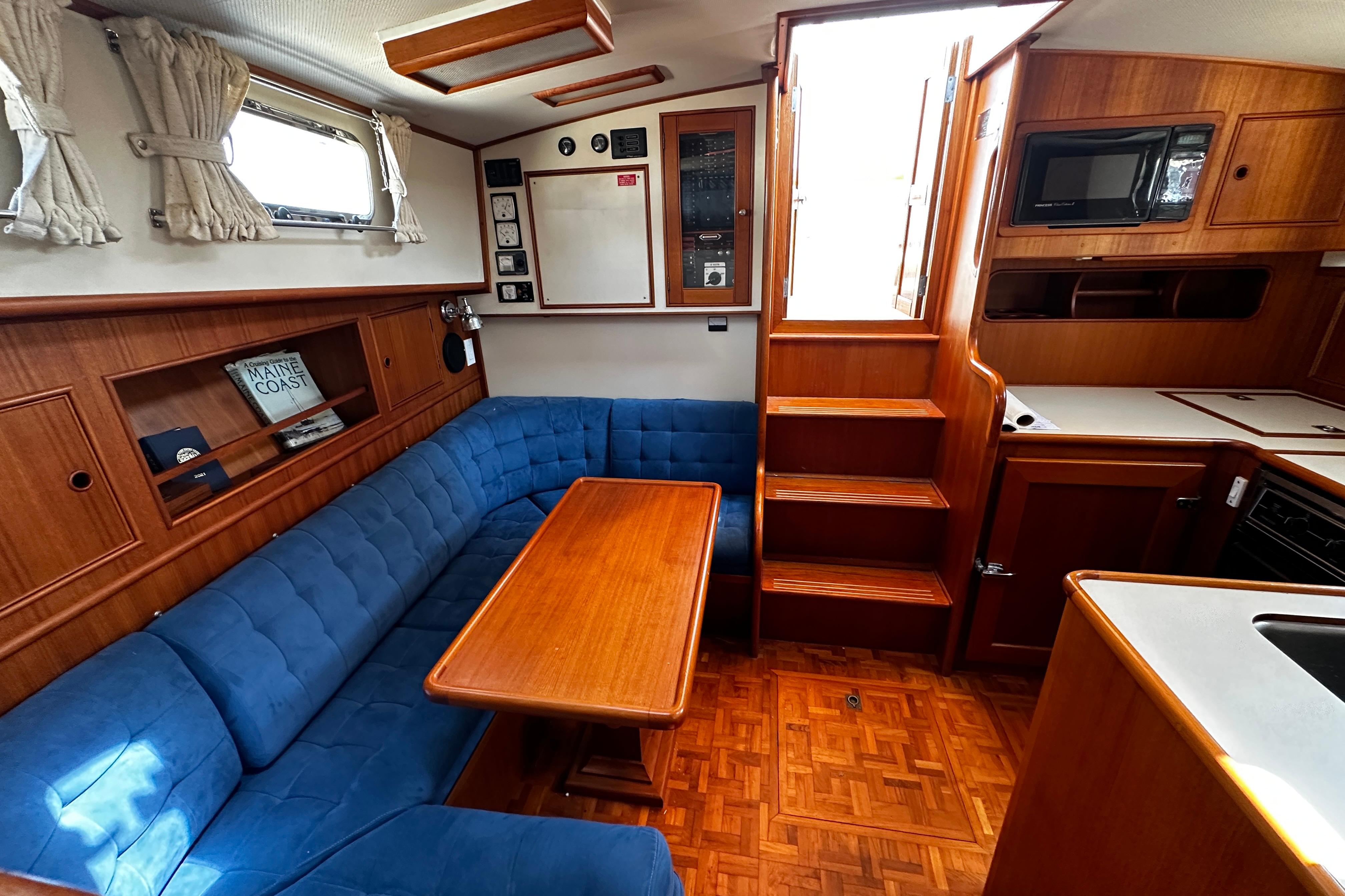 Interior of 1995 Grand Banks 38 Eastbay EX with blue seating and wooden finishes.