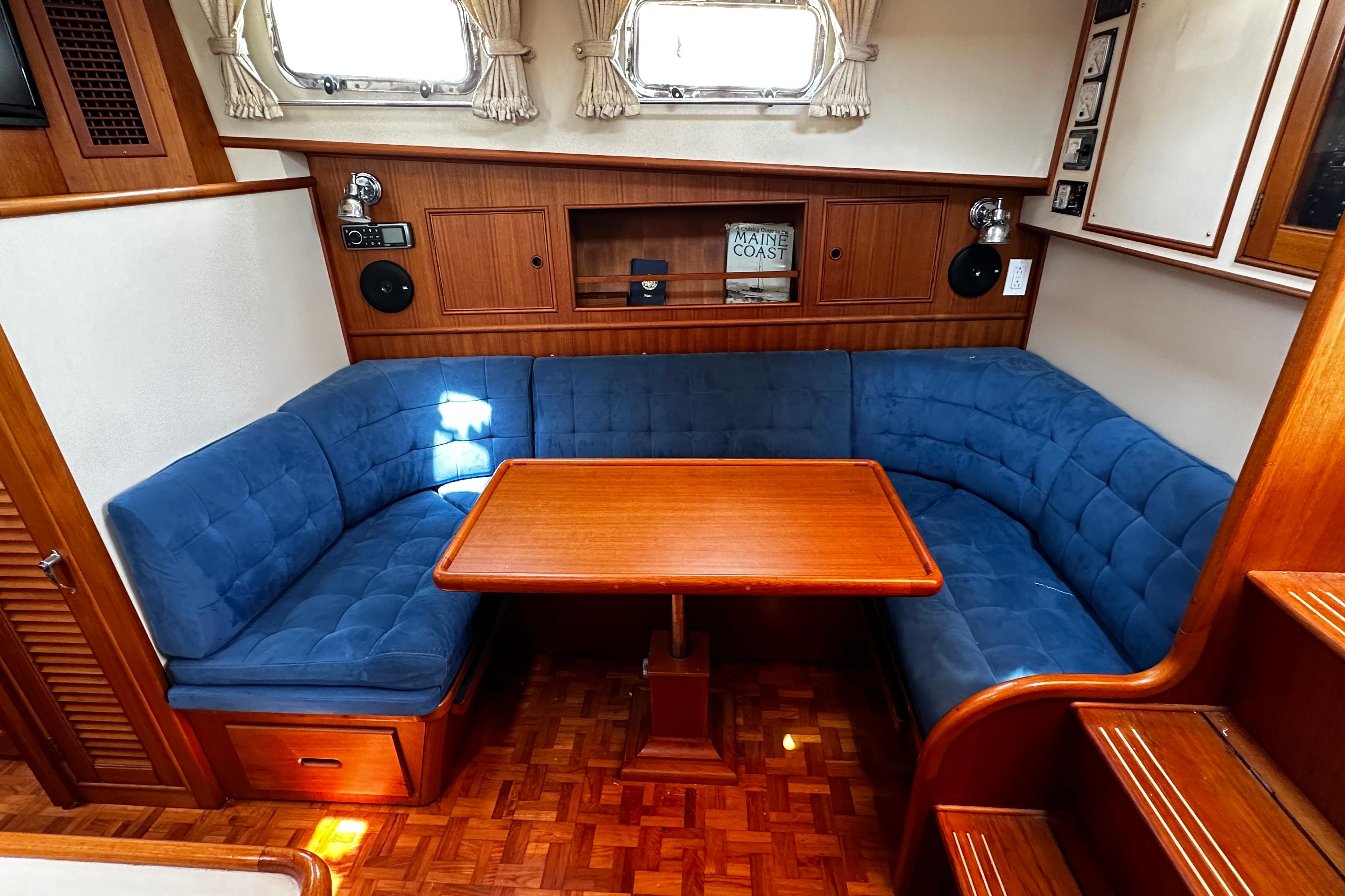 1995 Grand Banks 38 Eastbay EX interior with blue seating and wooden table.