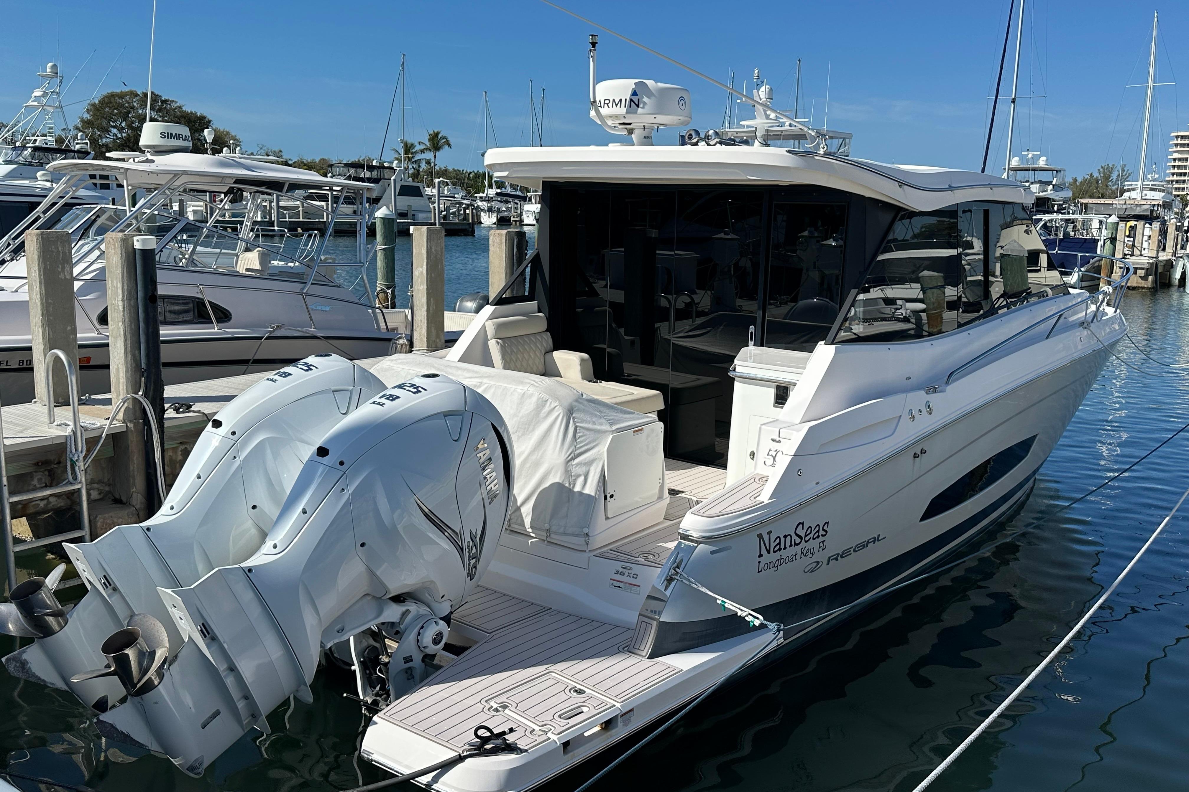 2021 Regal 36 XO boat docked with twin Yamaha outboard engines.