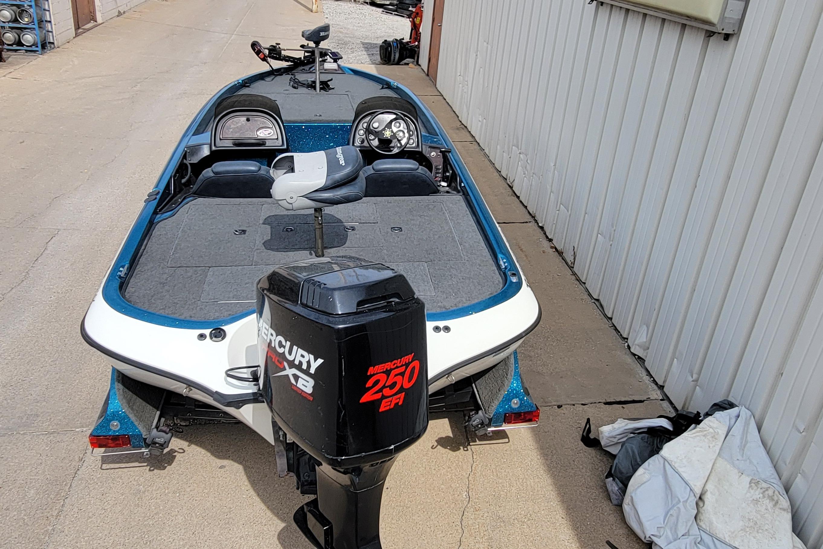 2000 Ranger 522DVX Comanche boat with Mercury 250 EFI engine, parked beside a building.