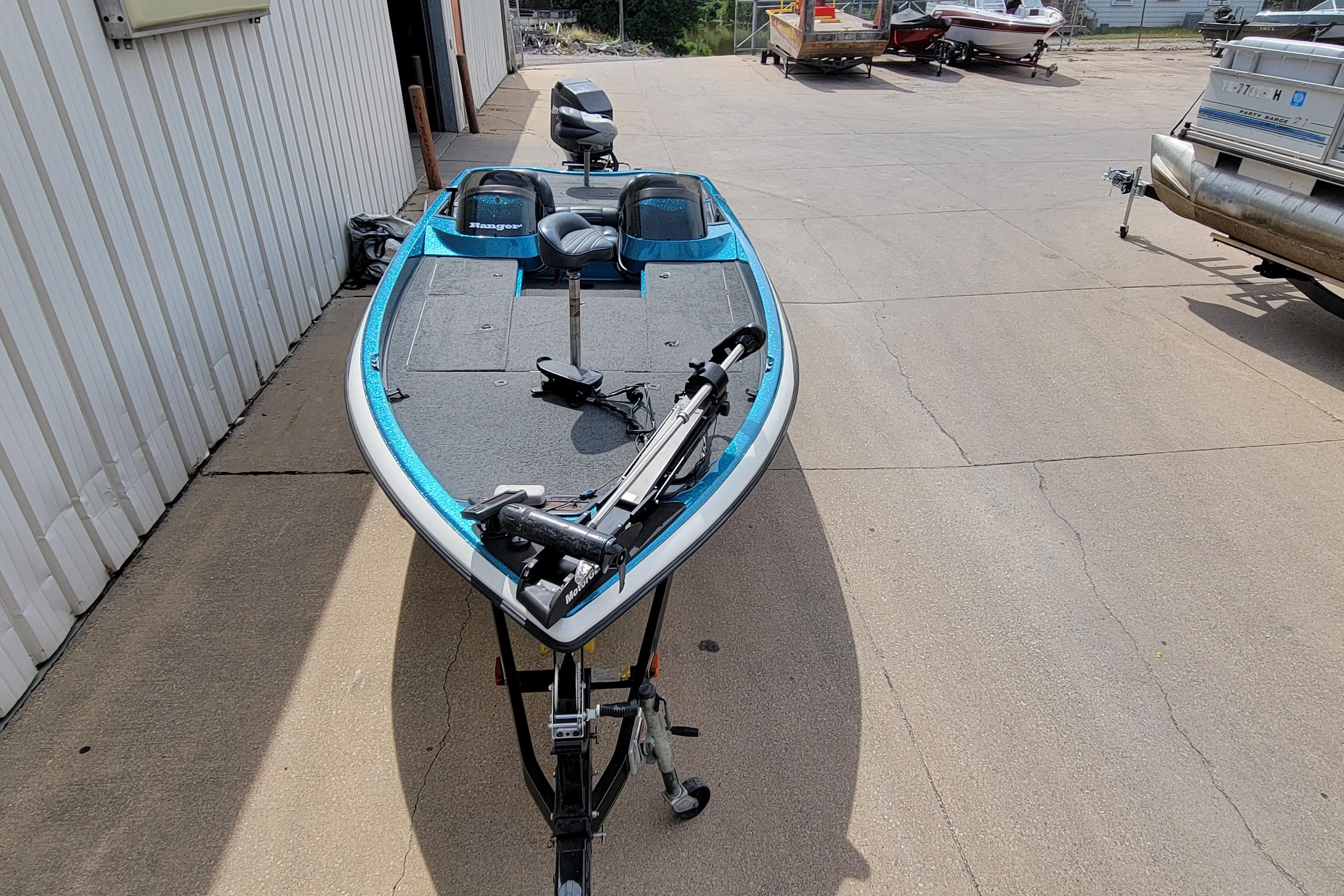 2000 Ranger 522DVX Comanche fishing boat parked on concrete near a building.
