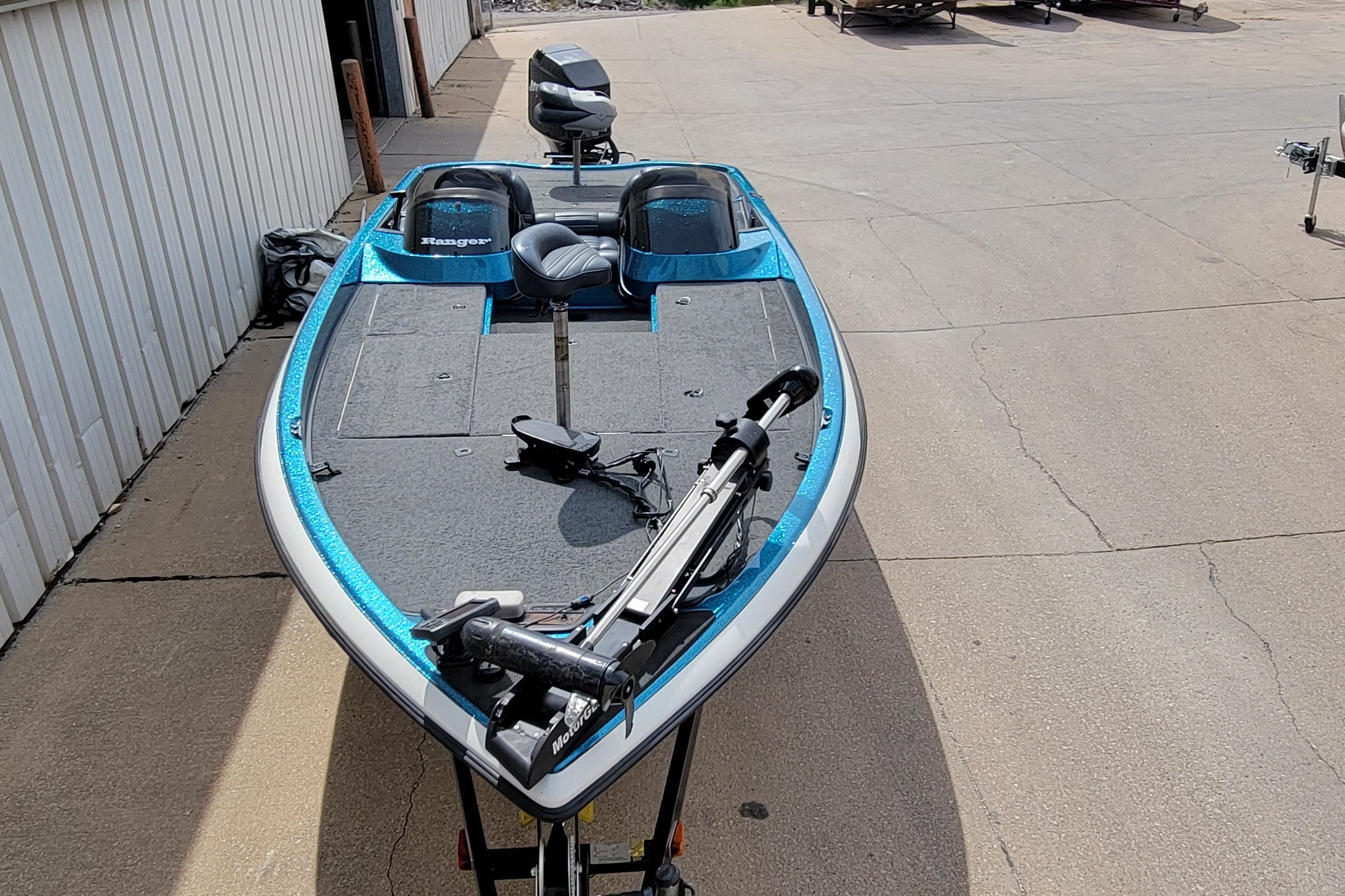 2000 Ranger 522DVX Comanche fishing boat with blue accents, parked on concrete.