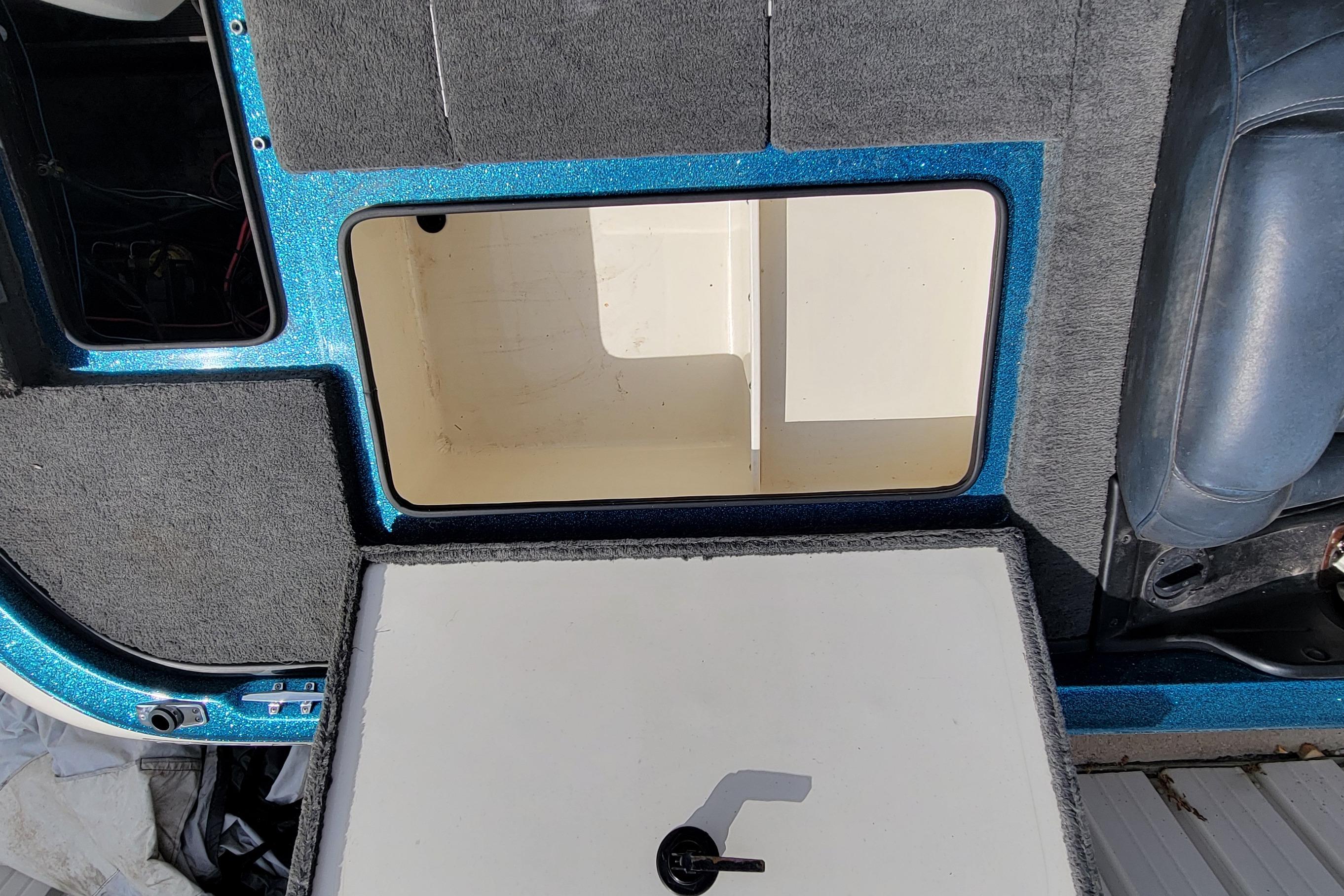 2000 Ranger 522DVX Comanche boat interior storage compartment with blue trim and gray carpet.