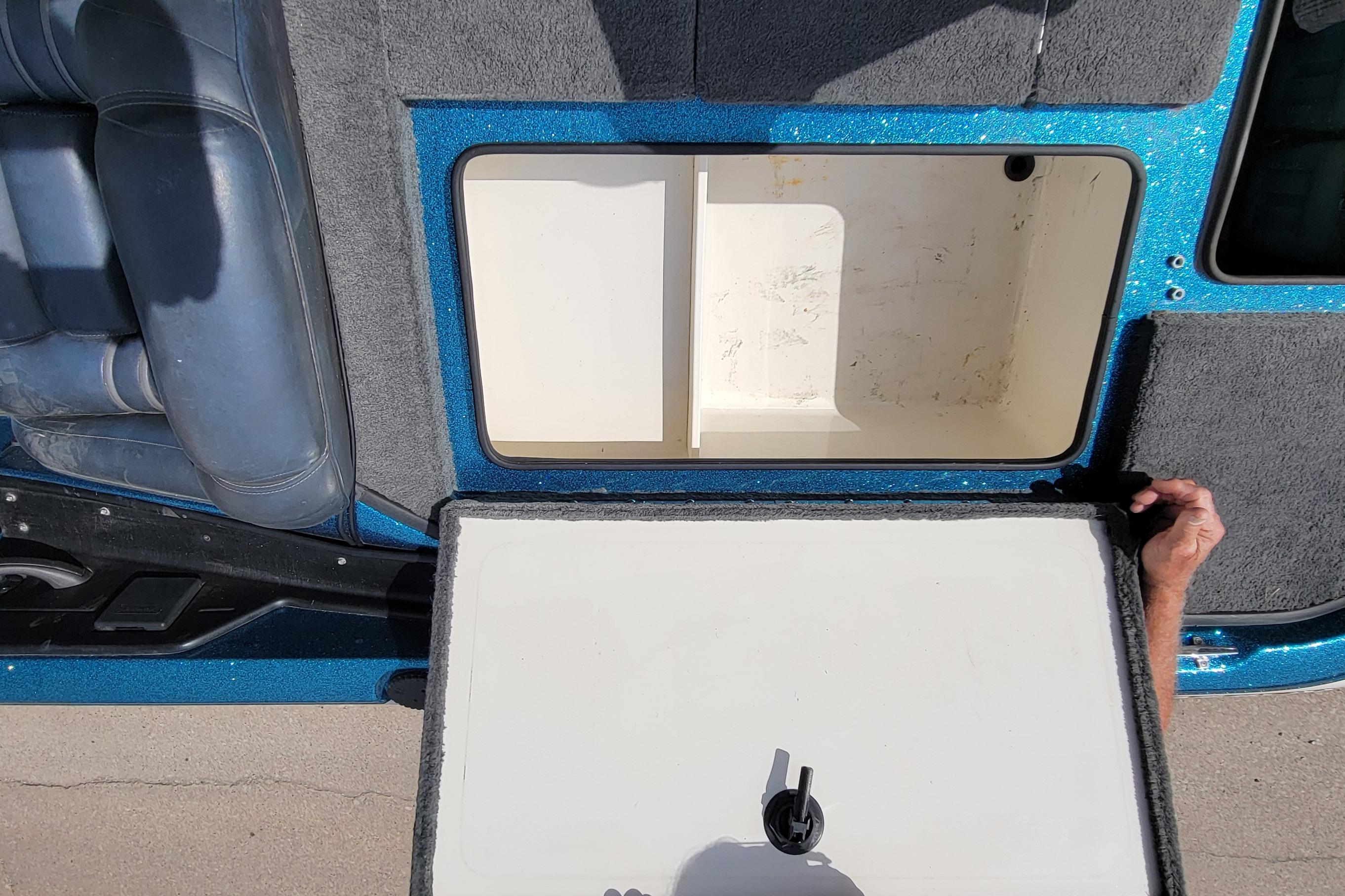 Open storage compartment in 2000 Ranger 522DVX Comanche boat, showing interior details.