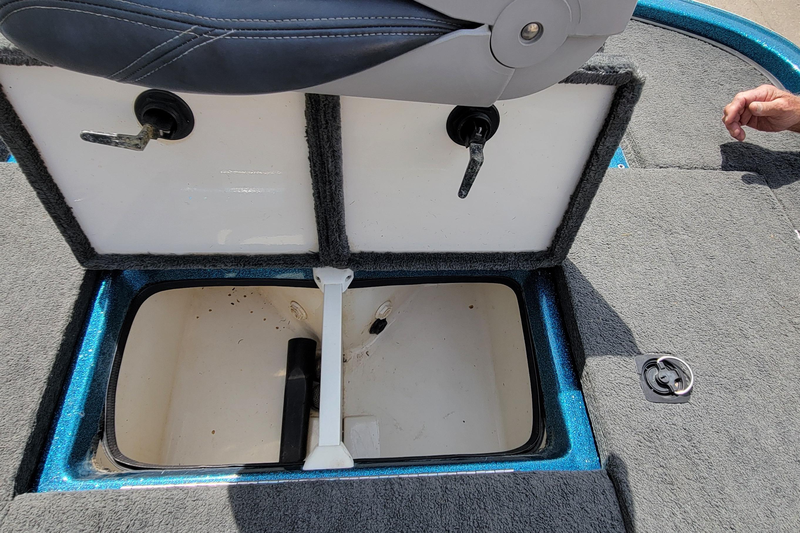 Open storage compartment in 2000 Ranger 522DVX Comanche boat, featuring carpeted interior and seat.