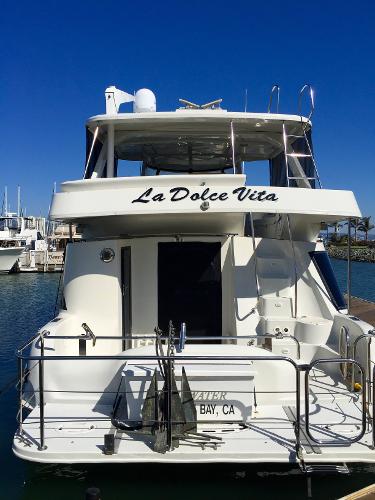 Rear view of 1999 Bluewater 5800 yacht docked in marina.