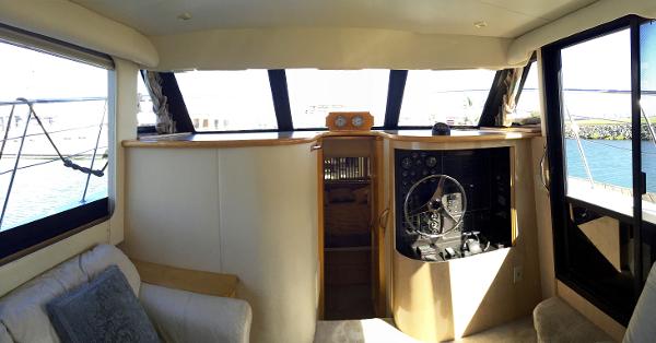 Interior of a 1999 Bluewater 5800 yacht, featuring helm and seating area.