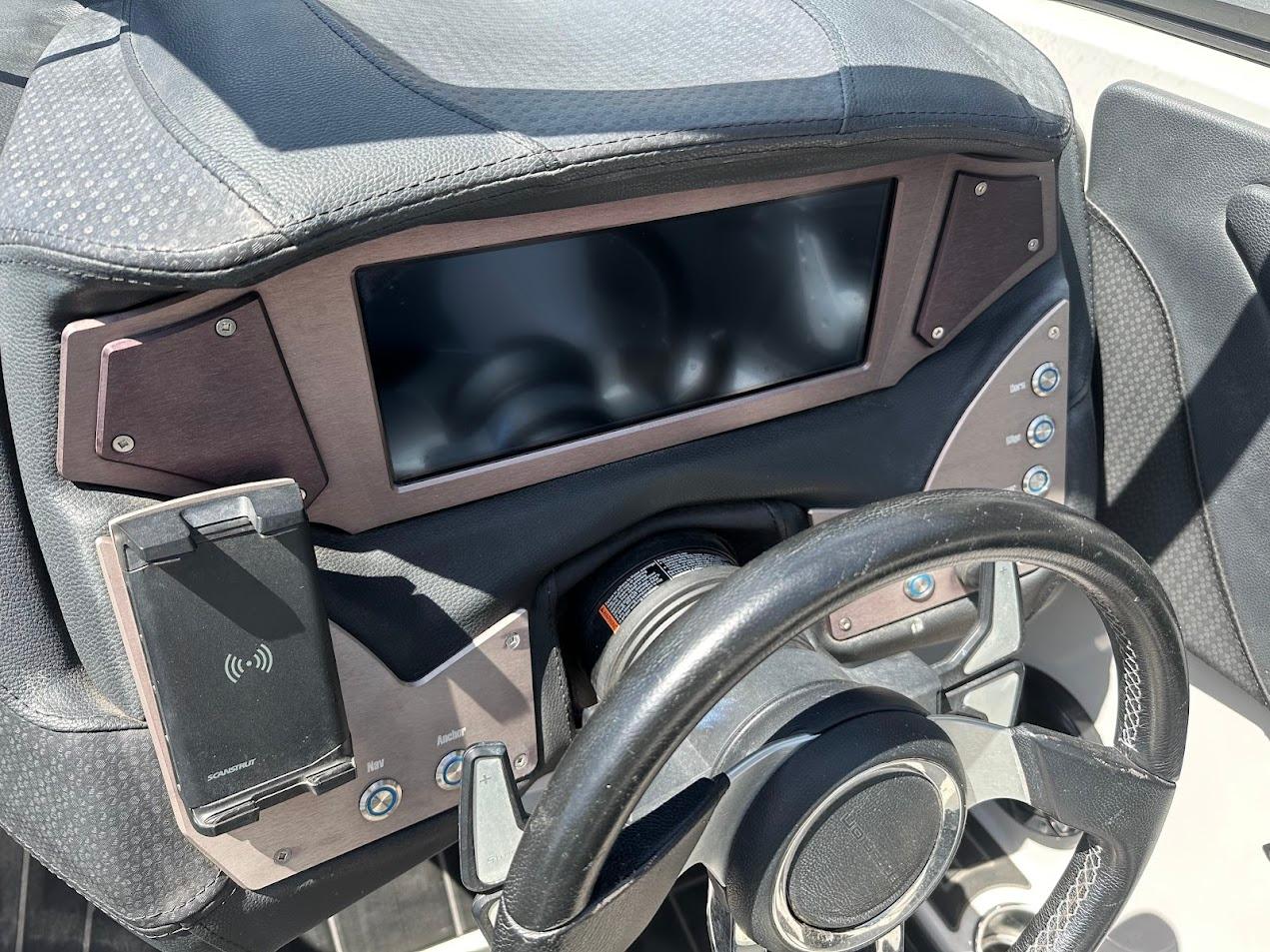 Dashboard of a 2021 Centurion Fi23 boat with steering wheel and control panel.