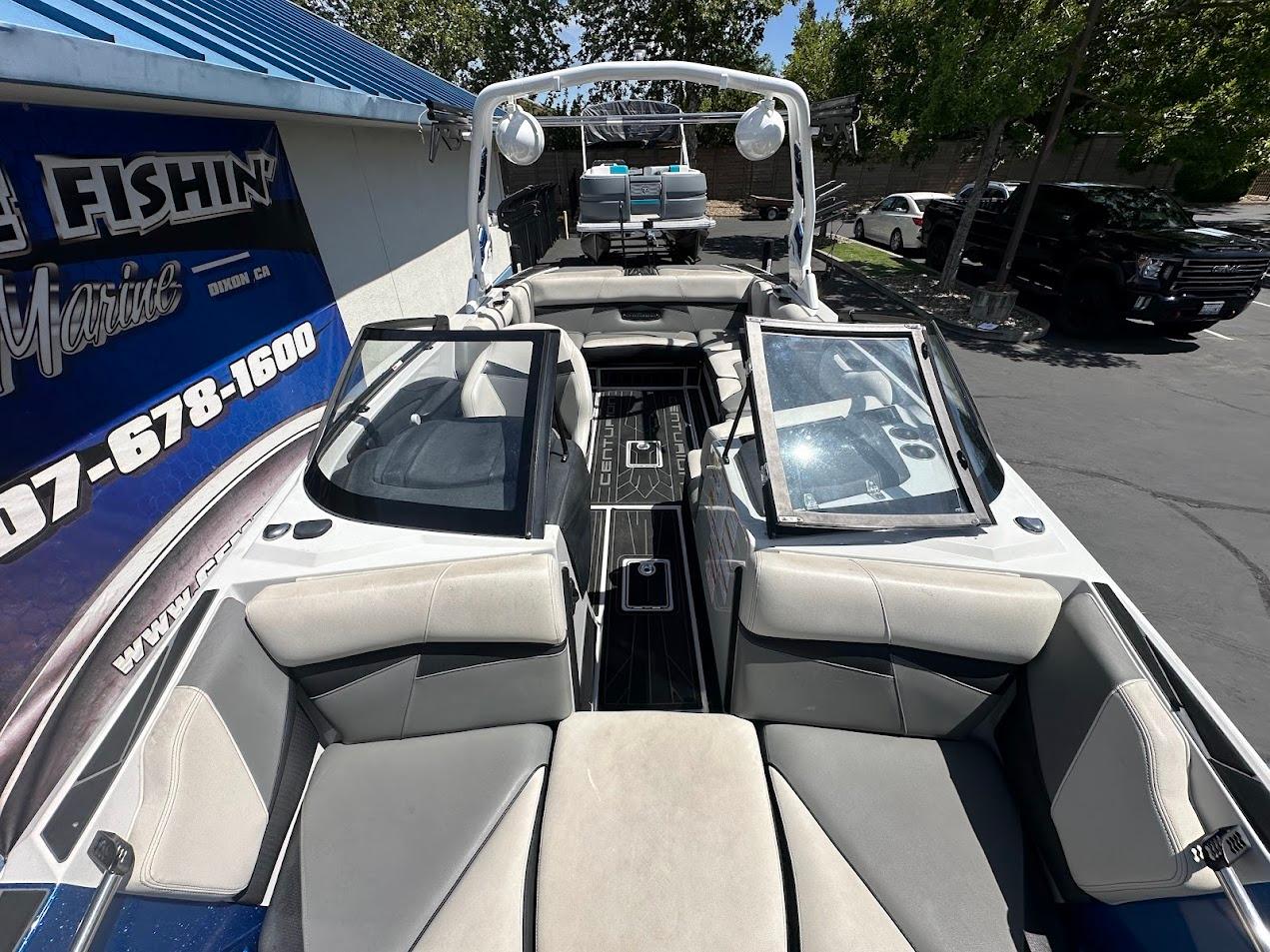 2021 Centurion Fi23 boat interior with open seating, parked near a marine shop.