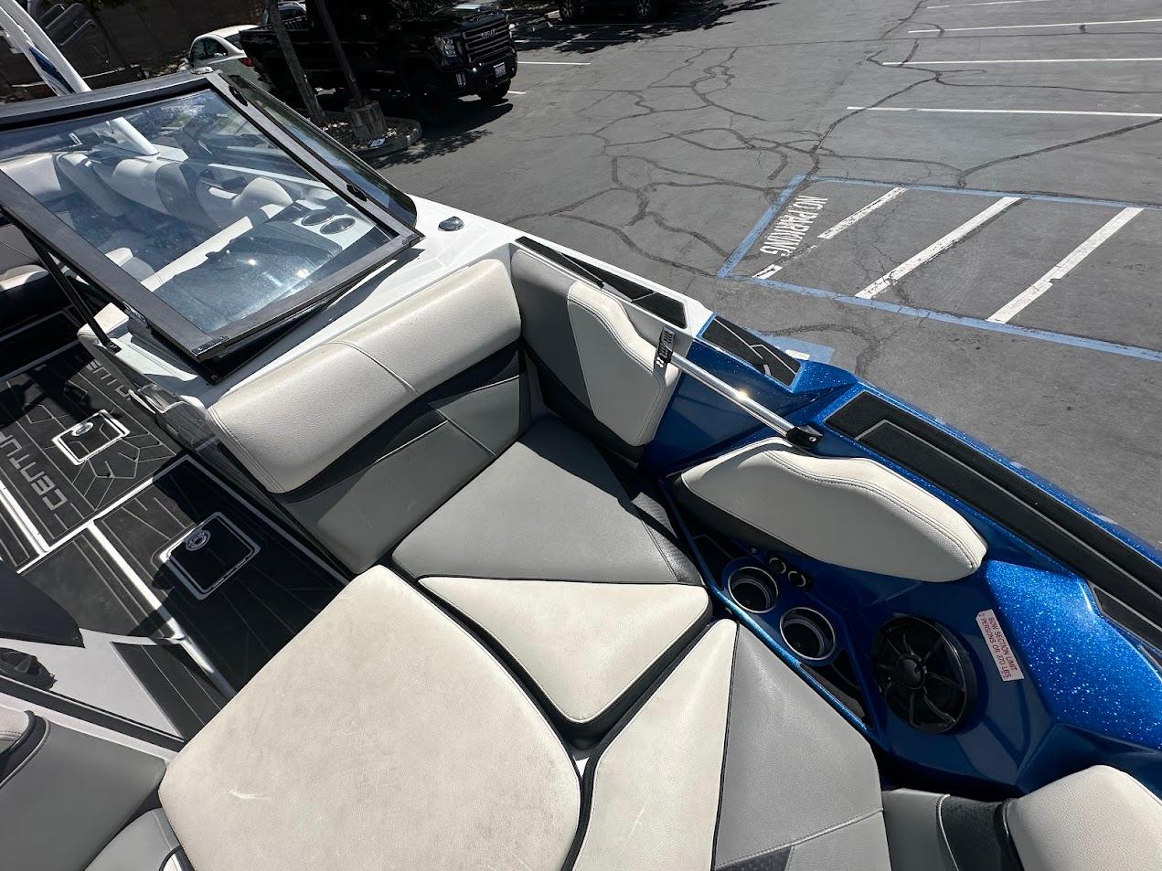 2021 Centurion Fi23 boat interior with gray seating and blue accents in a parking lot.