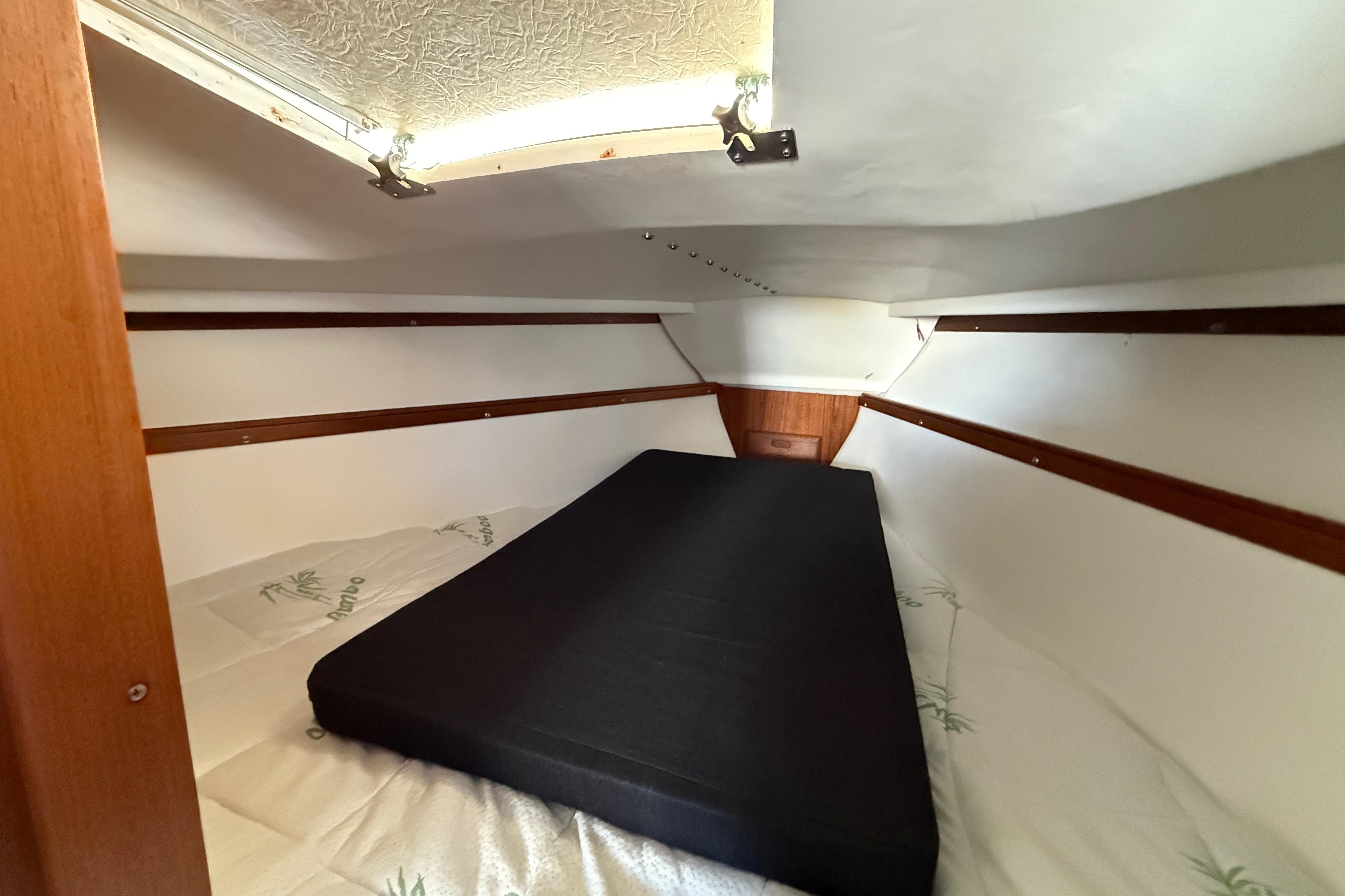 Interior cabin of a 1981 Catalina 30 sailboat with a black mattress.