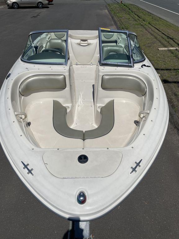 2004 Sea Ray 185 Sport boat, white exterior, spacious seating, parked on pavement.