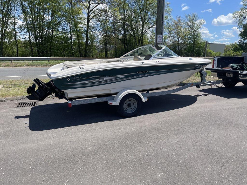 2004 Sea Ray 185 Sport boat on trailer, parked outdoors on a sunny day.