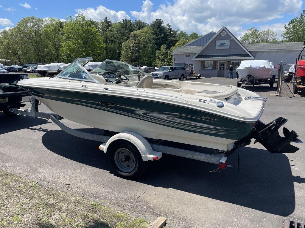 2004 Sea Ray 185 Sport boat on trailer, parked outdoors under a partly cloudy sky.