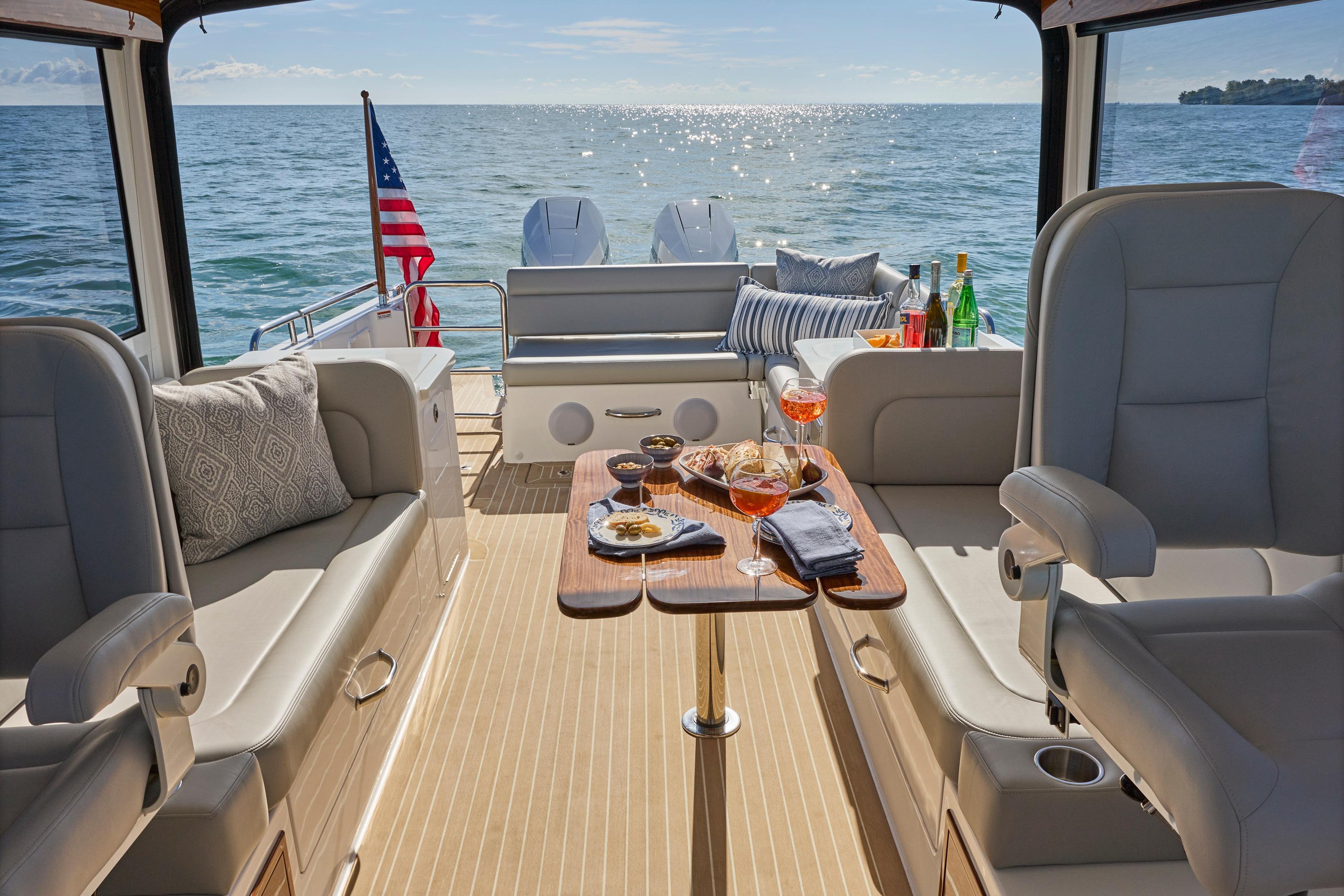 Luxurious 2026 MJM 38 X yacht interior with elegant seating, table, and ocean view.
