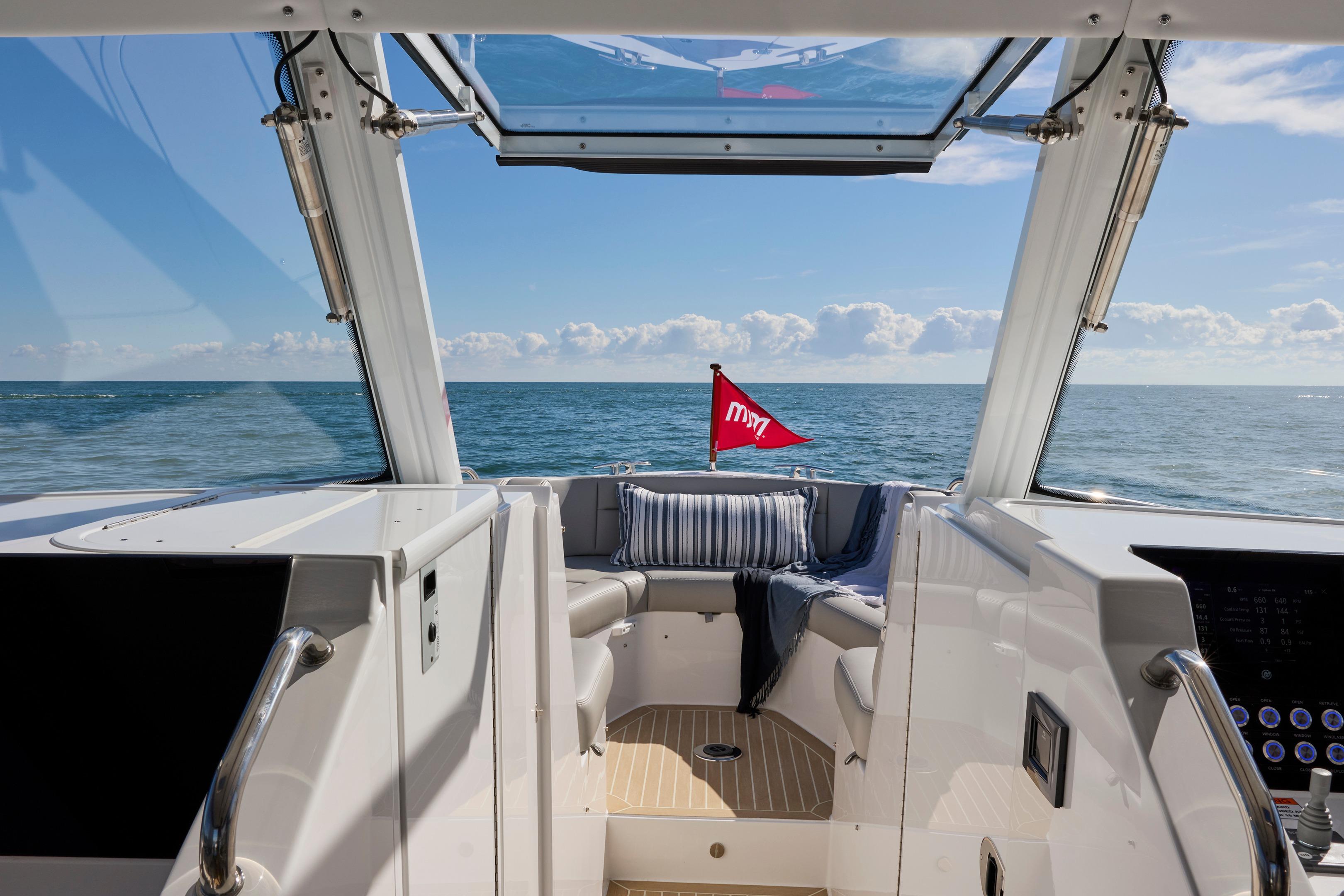 Interior view of 2026 MJM 38 X yacht with ocean backdrop and red flag.