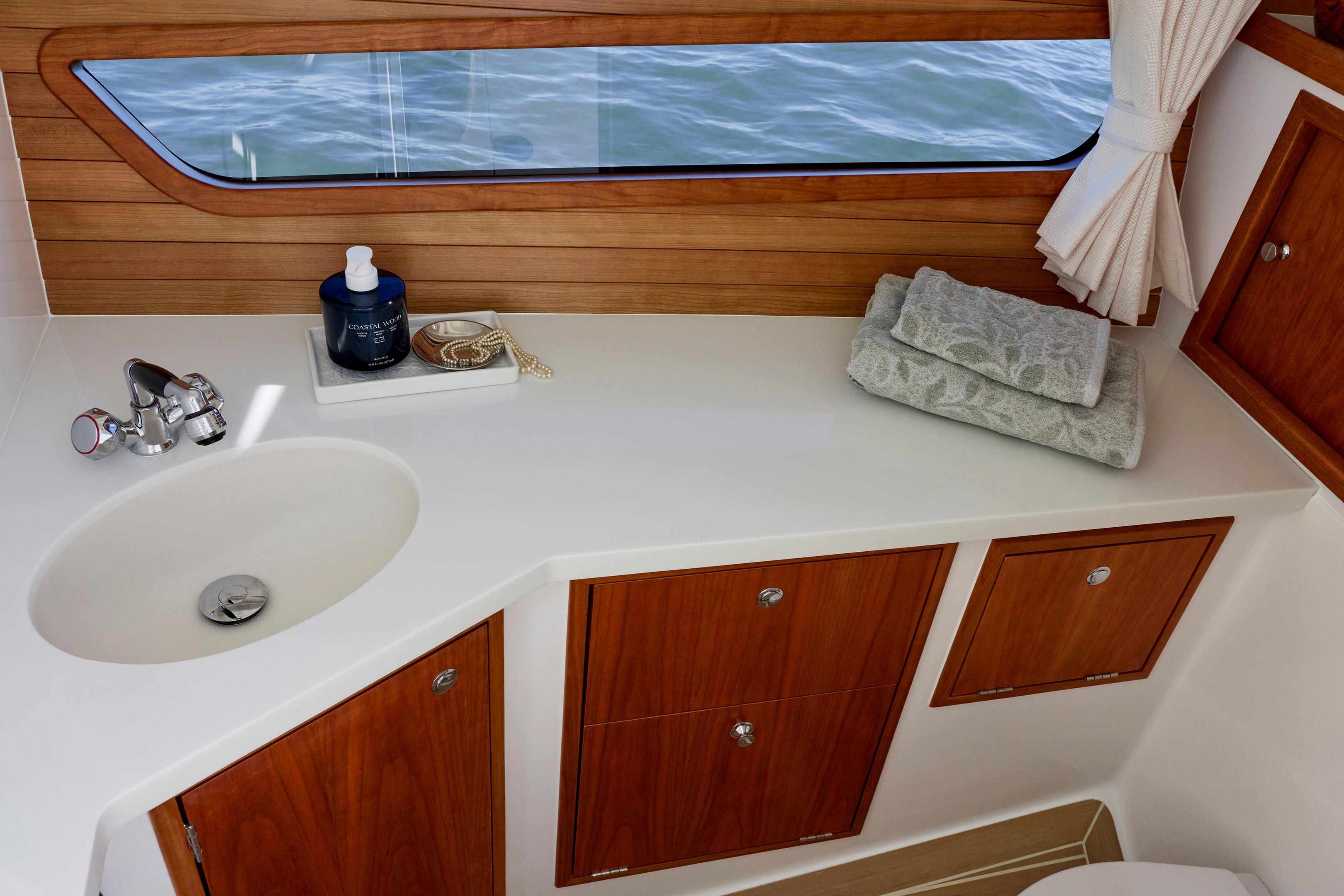 Luxurious bathroom interior of 2026 MJM 38 X yacht with wooden cabinetry and ocean view.