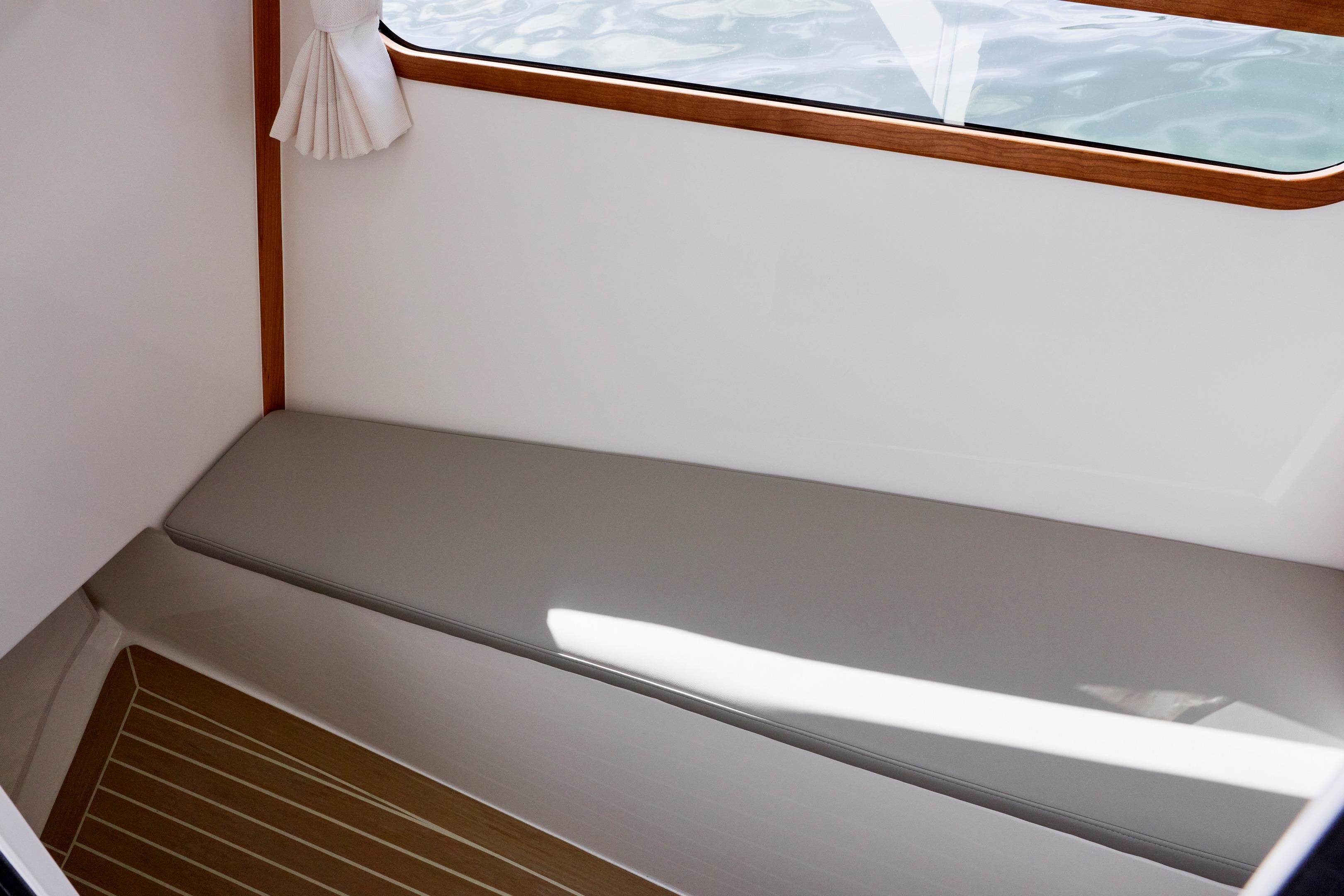 Interior of 2026 MJM 38 X boat with cushioned seating and wooden accents.