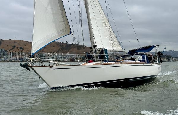1983 Tayana 52 Aft Cockpit sailboat cruising on a cloudy day.