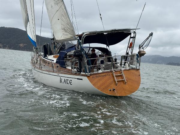 1983 Tayana 52 Aft Cockpit sailboat navigating on a cloudy day.