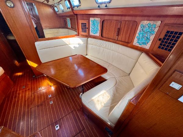 1983 Tayana 52 Aft Cockpit interior with wooden flooring and cream seating.
