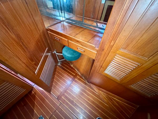 Wooden interior of 1983 Tayana 52 Aft Cockpit yacht with vanity and stool.