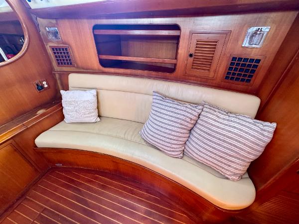 Cozy seating area in 1983 Tayana 52 Aft Cockpit yacht with striped cushions.